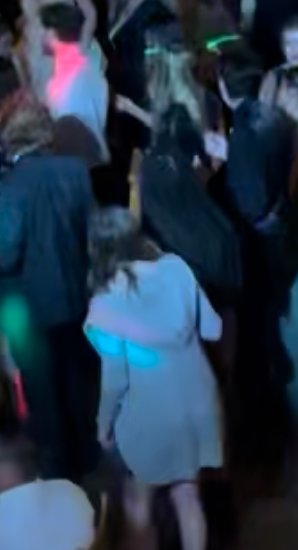 People dancing at a party or club with neon lights.