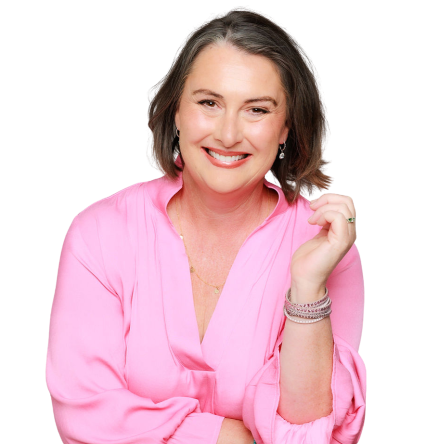 Smiling woman with shoulder-length wavy hair wearing a pink blouse and jewelry talking about menopause after cancer