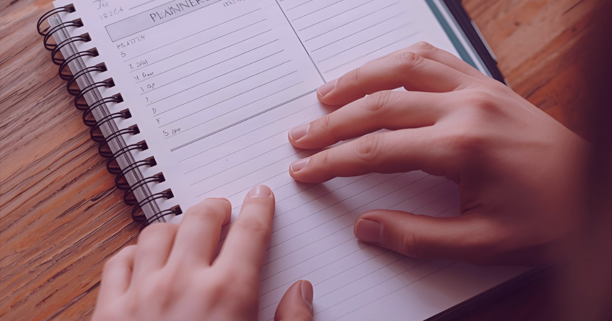 Hands resting on an open planner, representing slow, steady progress during a challenging year.