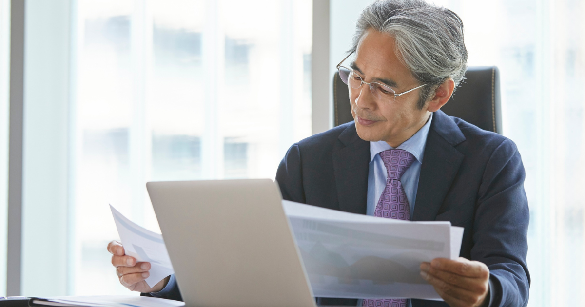 Professional reviewing documents at a desk, representing preparation for government contracting work.