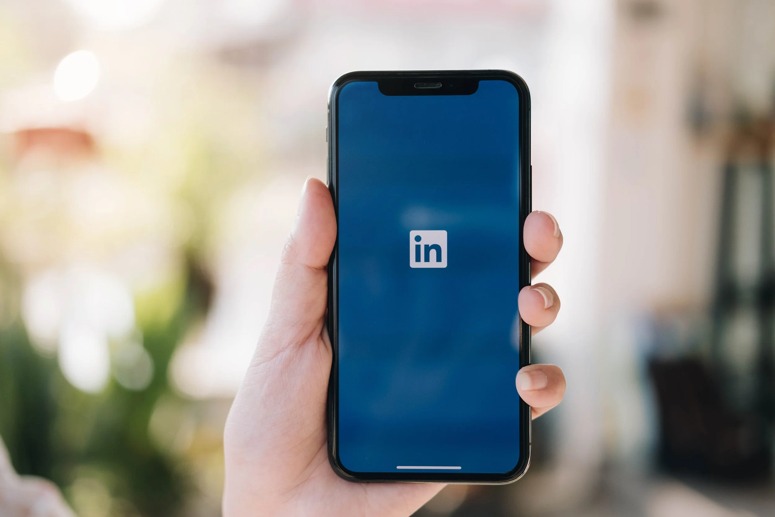 Someone holding a phone that the LinkedIn app showing