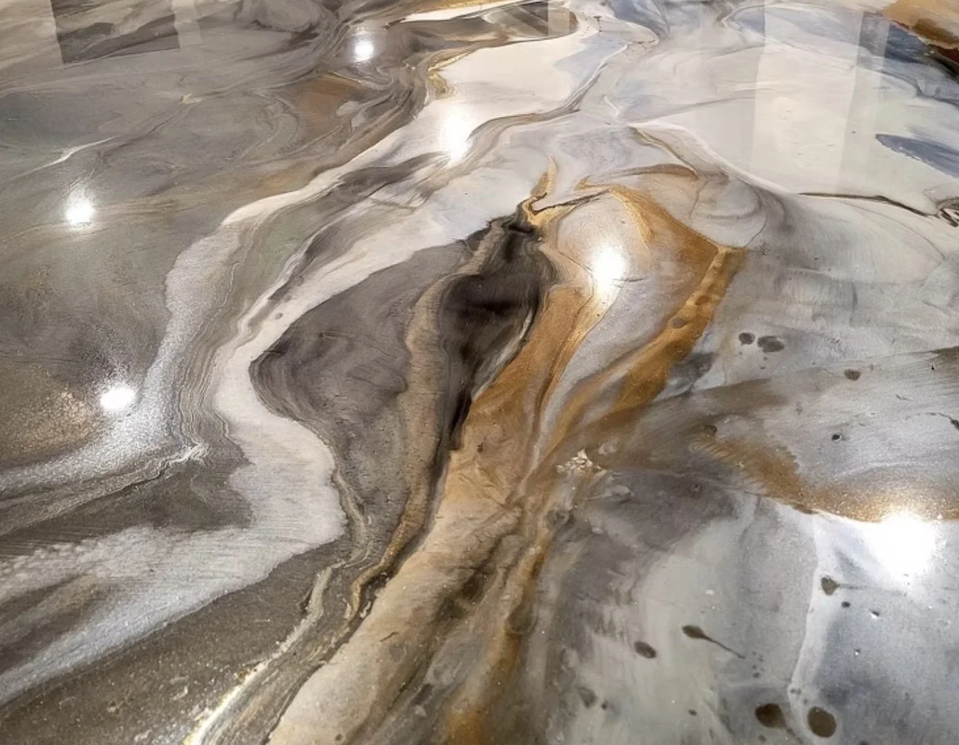 Close-up of a marble or stone surface with swirling patterns of gray, white, black, and brown colors.