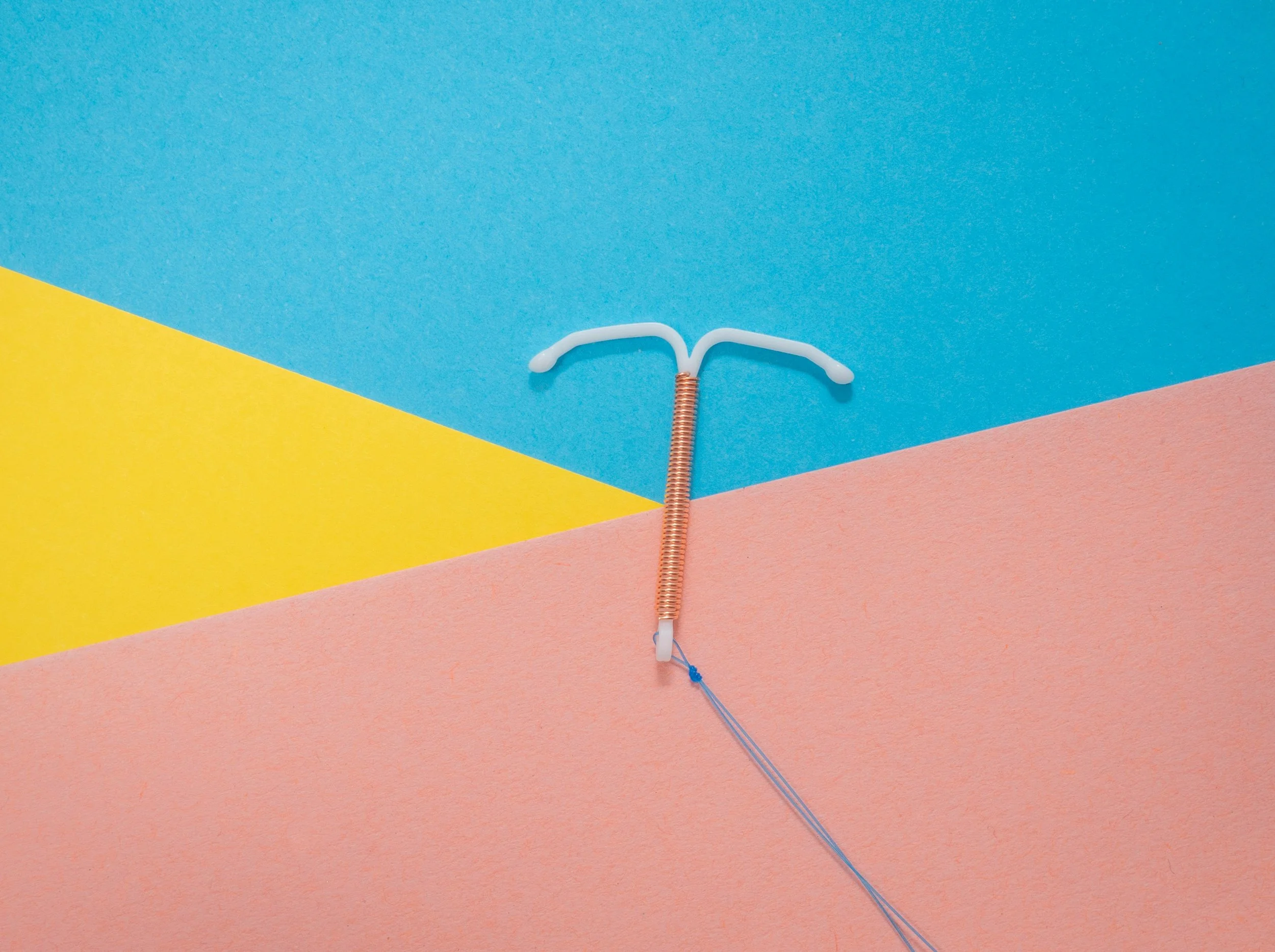Copper IUD on colorful geometric background