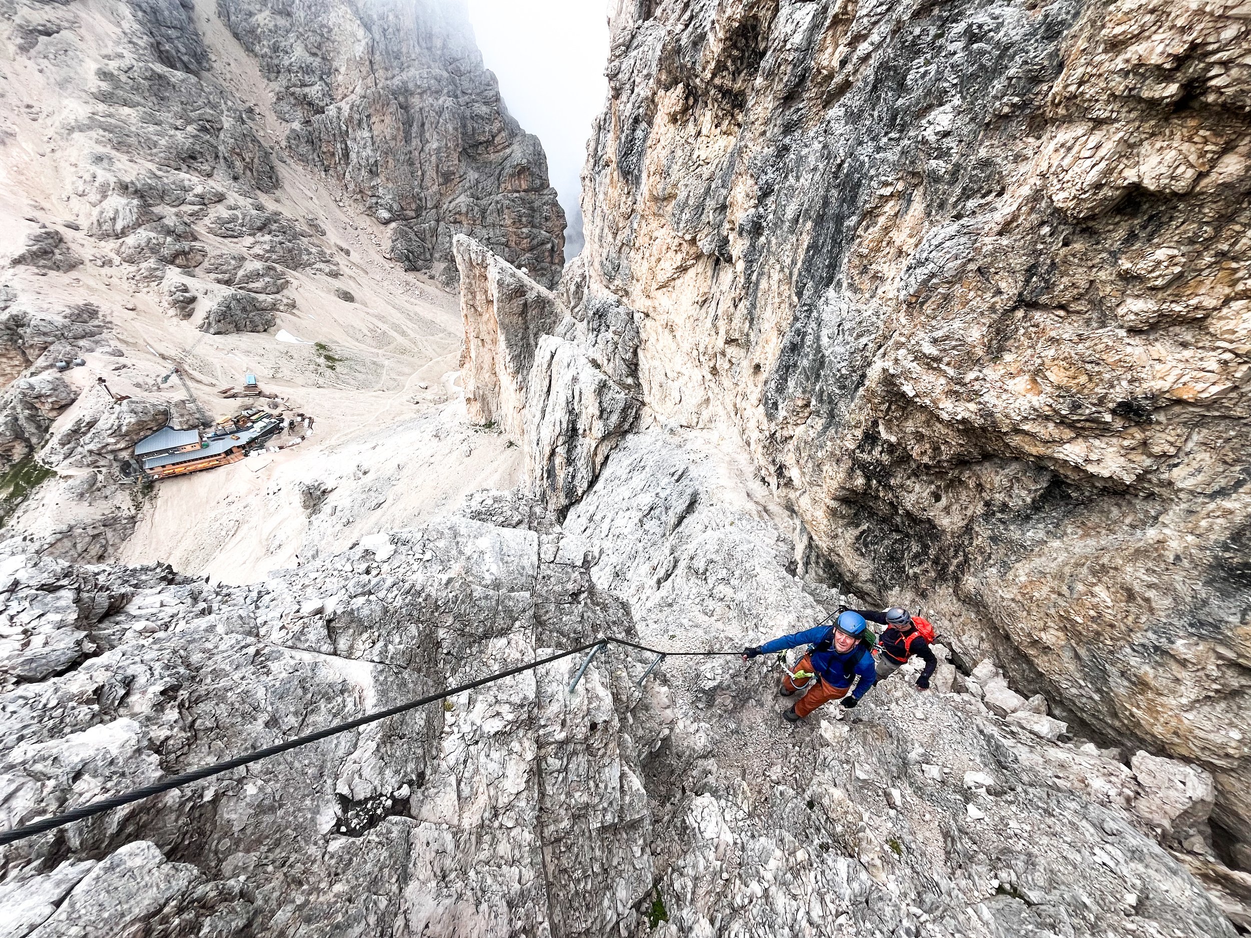 Two climbers following their mountain guide filippo barbieri, in the Antermoia via ferrata, starting from Rifugio Principe and arriving at Rifugio Antermoia. Great scenery on the valley.