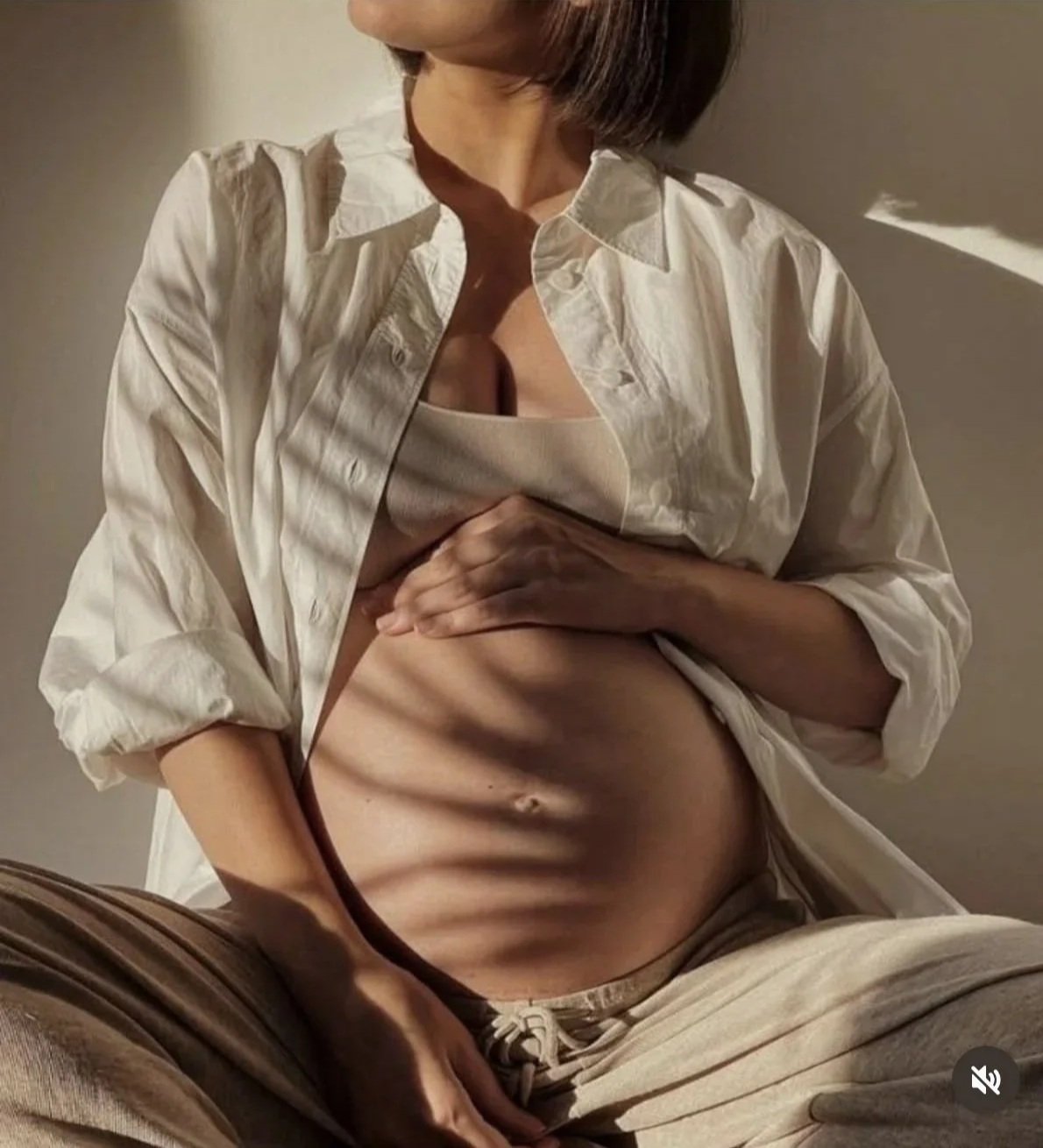 this is an image of a pregnant  women with her hands on her baby bump
