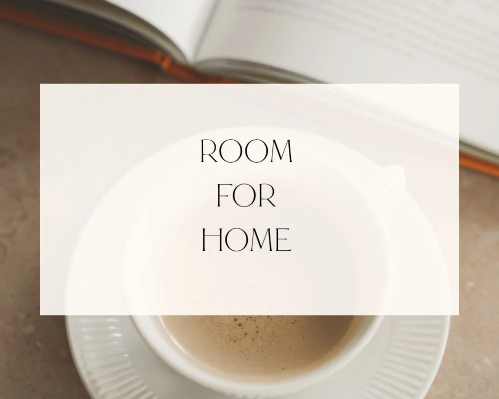 A white cup of coffee on a saucer with a book in the background and a text overlay that says 'Room for Home'.
