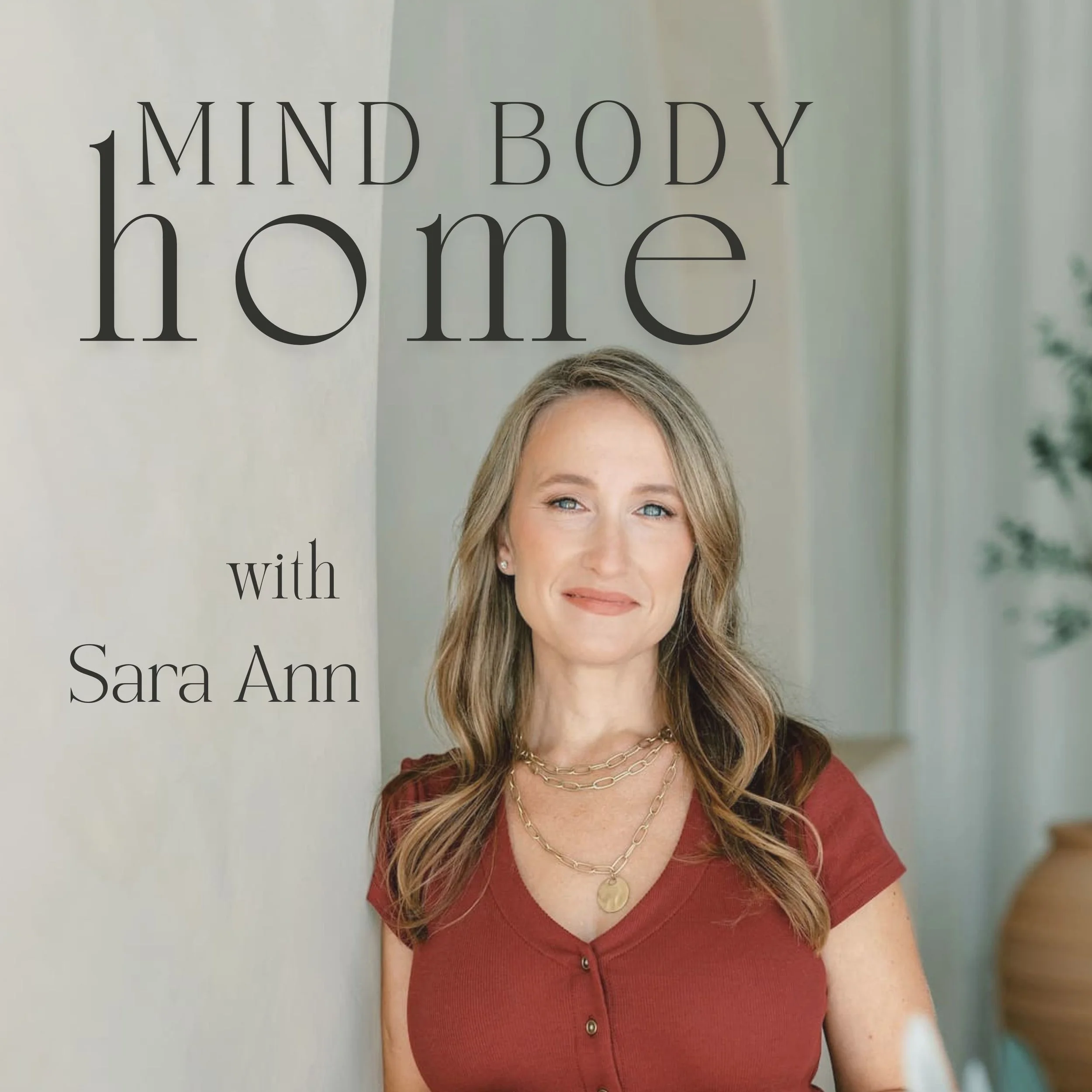 Mind Body Home podcast with Sara Ann in red dress against neutral living space posing for podcast cover art
