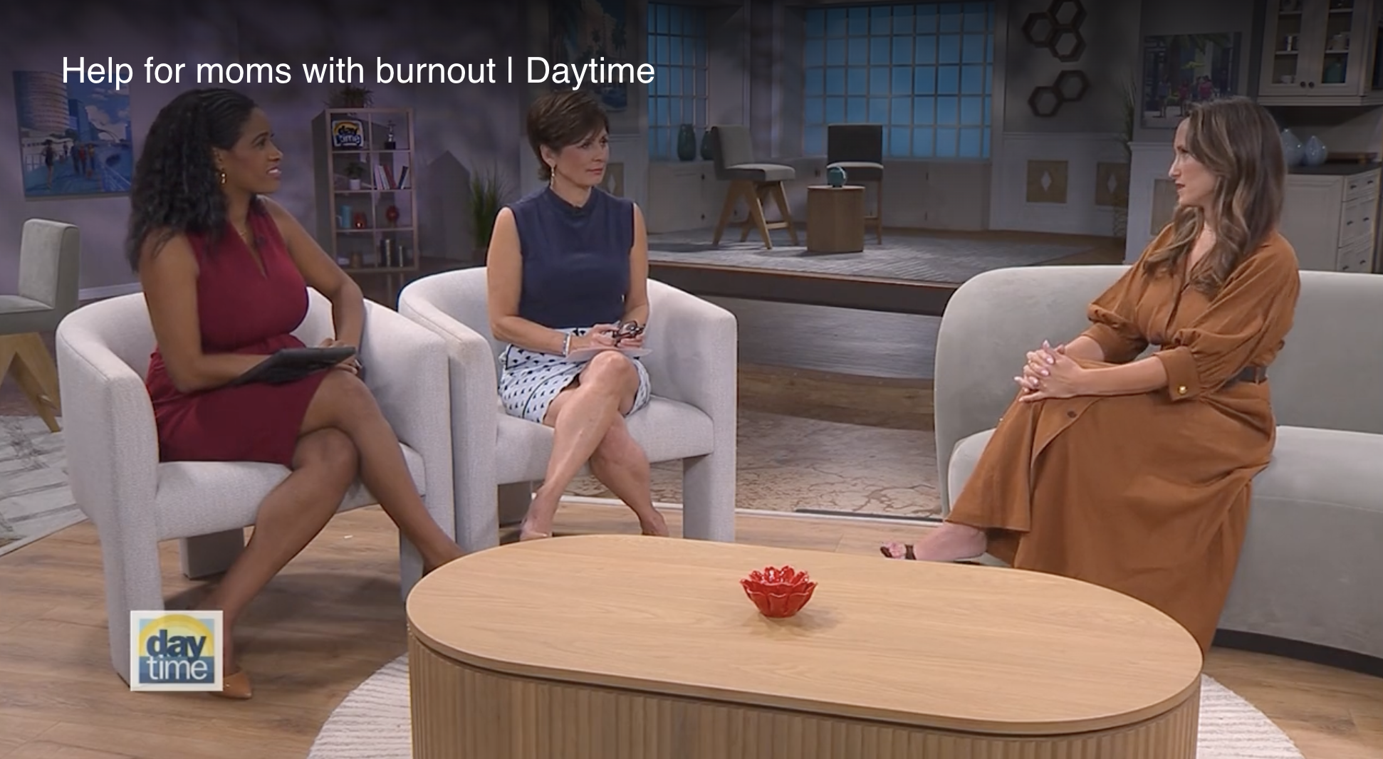 Sara Ann in long brown dress sits on sofa across form Daytime TV hosts Farron Hipp and Maggie Rodriguez.