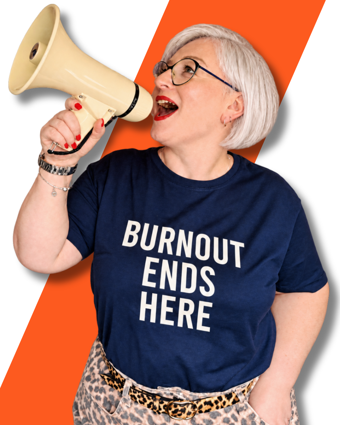 A woman with short gray hair, glasses, and red lipstick wearing a navy blue T-shirt that says 'BURNOUT ENDS HERE'. She is holding a beige megaphone to her mouth and appears to be shouting. She is also wearing leopard print pants and a leopard print belt with jewelry and red nail polish.