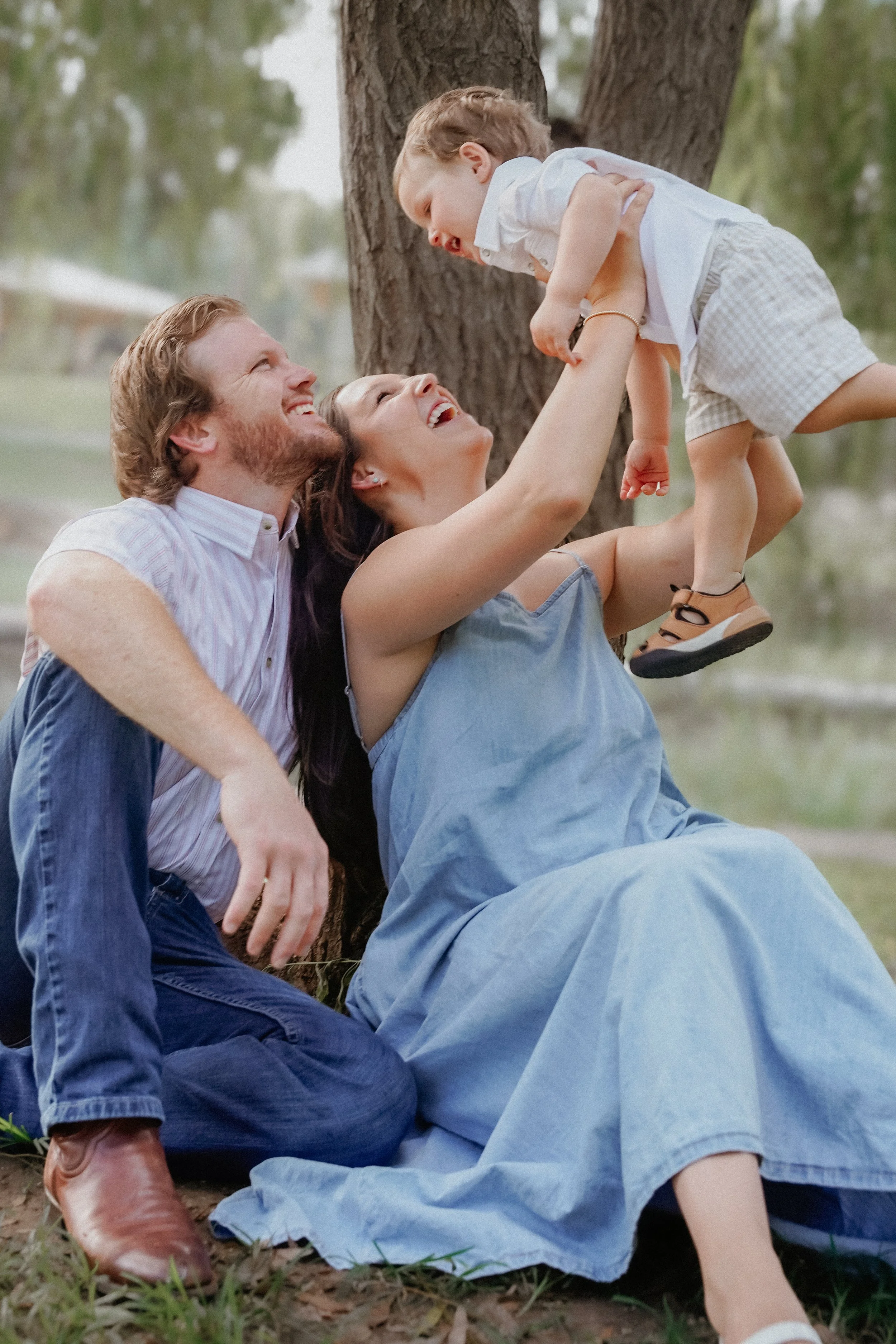 Austin Photographer Pricing. Family photography session in Landa Park New Braunfels. Mom holding baby in the air.