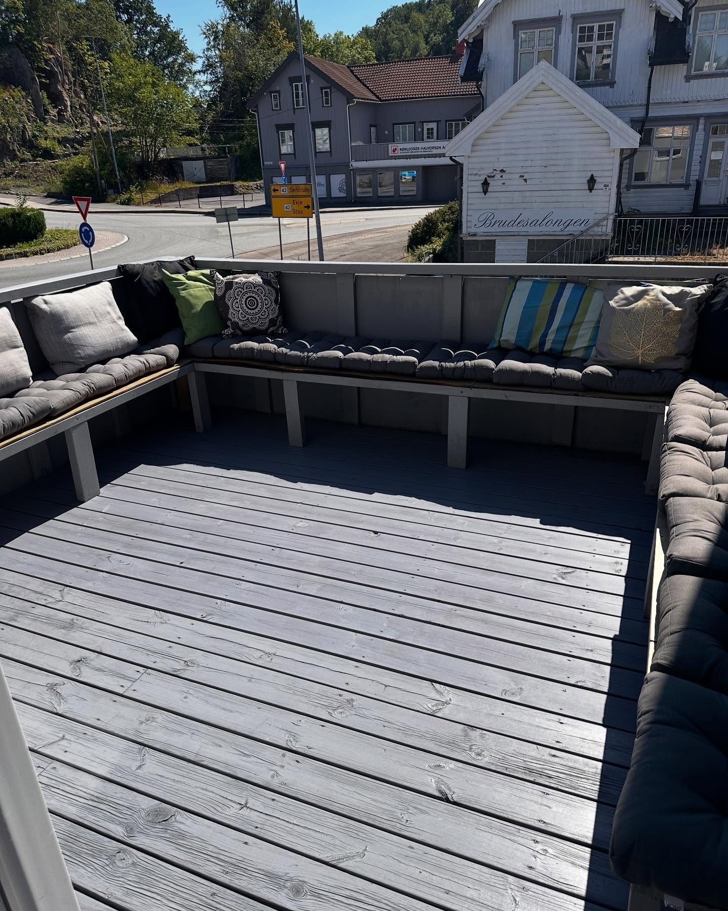 Uteplass med sittebenker og puter.