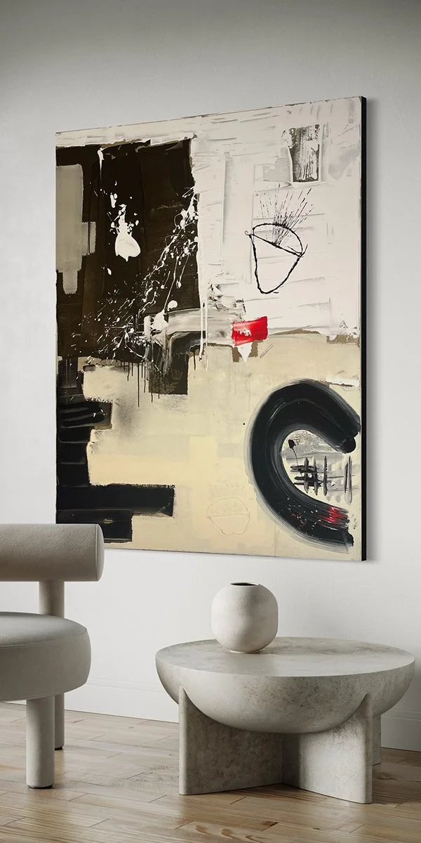 Modern abstract painting hangs on a white wall above a round stone table with a small round white vase.