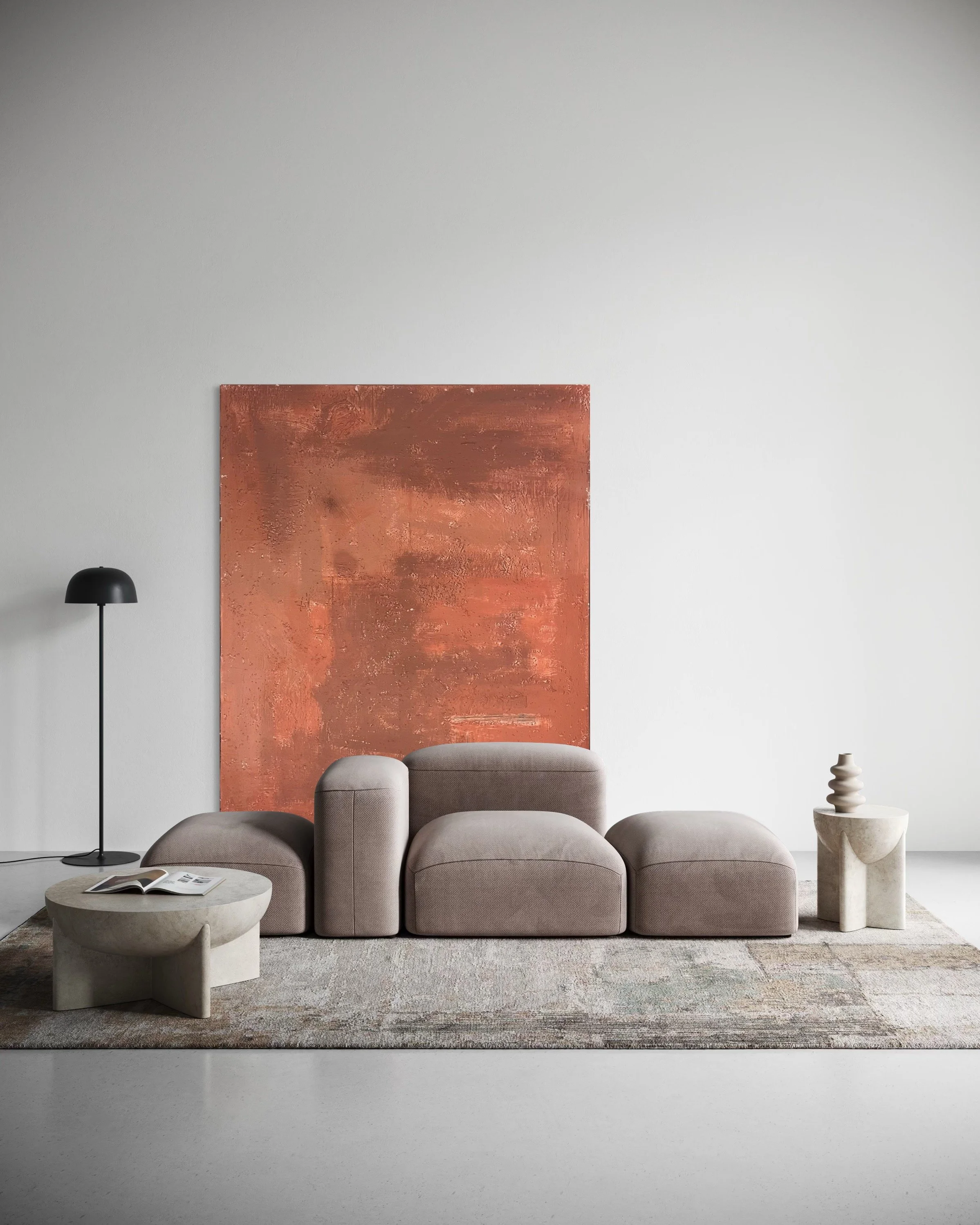 Minimalist living room with beige modular sofa, abstract artwork on the wall, black floor lamp, and small side tables with decorative objects