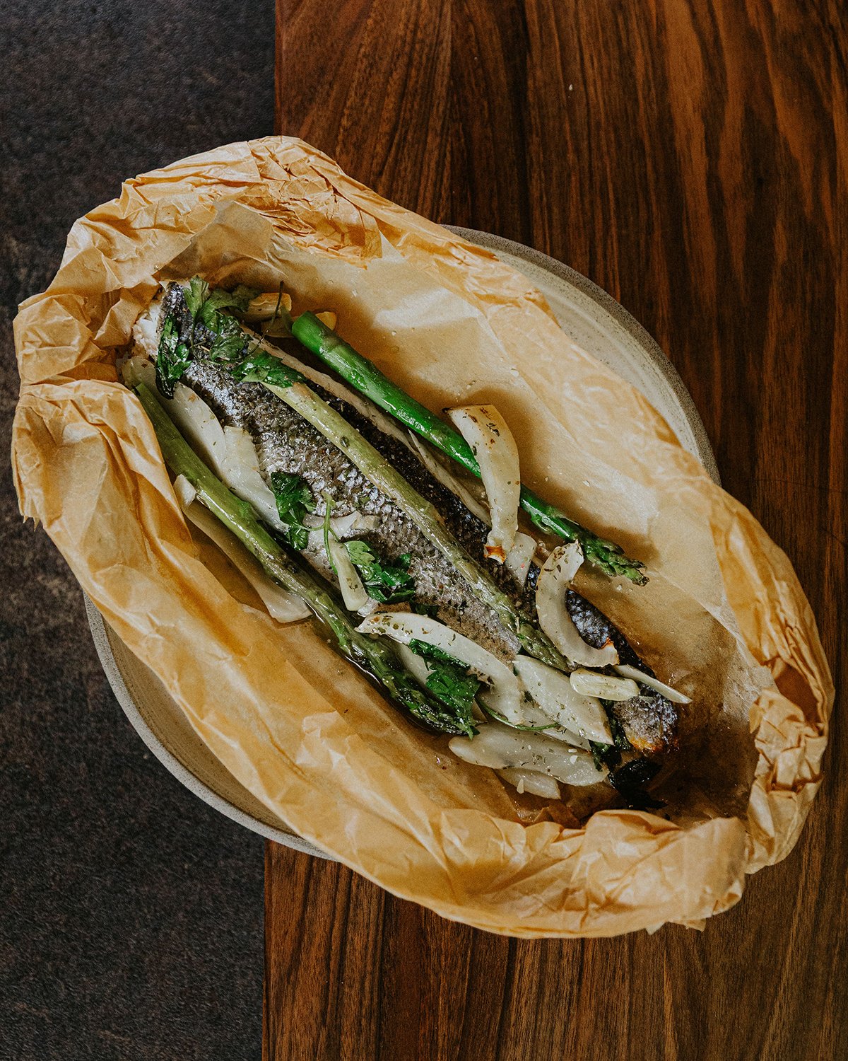 tengeri sügér papírba zárva, tárkonnyal és zöld spárgával