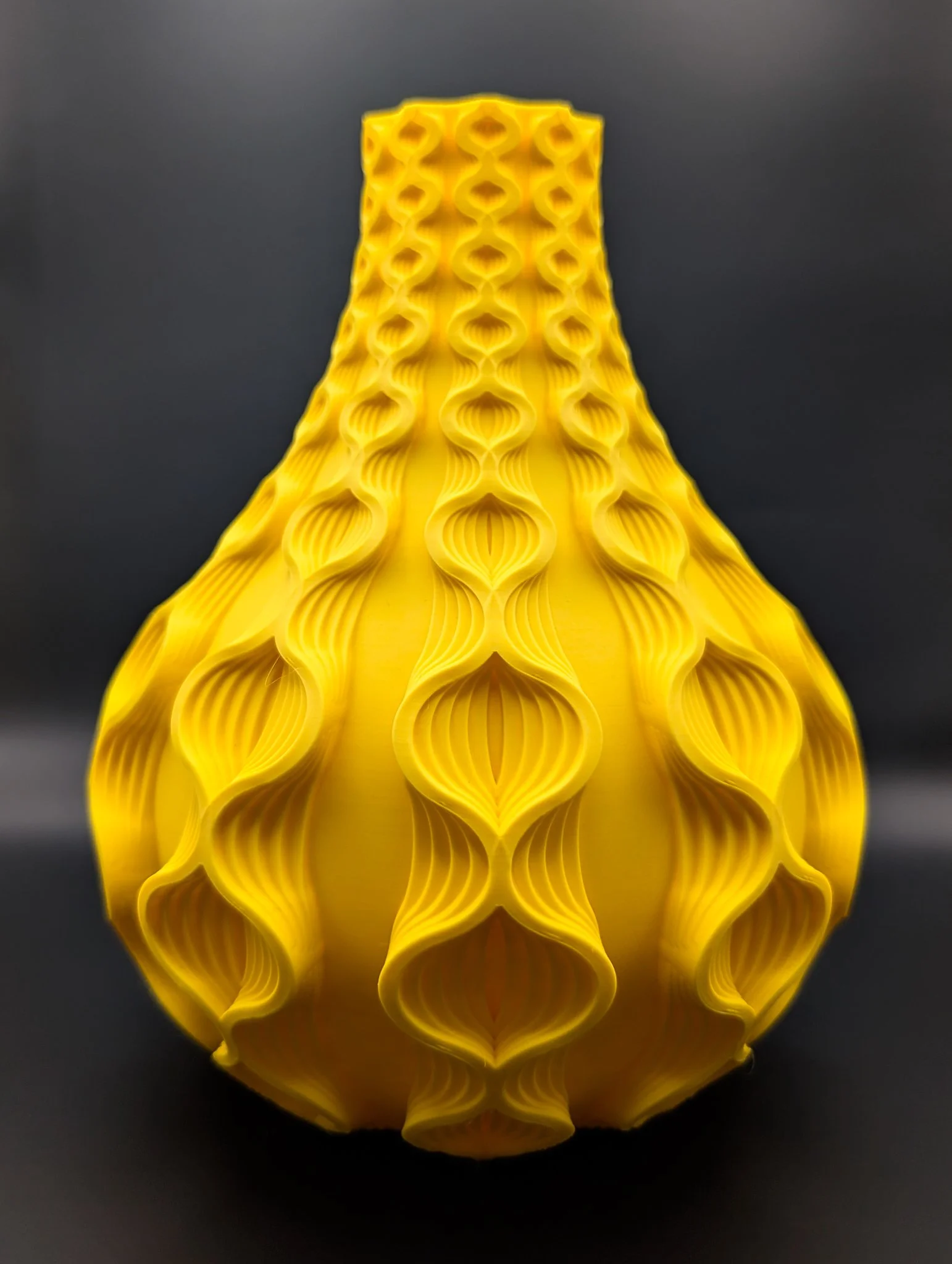 Gele 3D-geprinte structuur met een holle, gegroefde patronen.