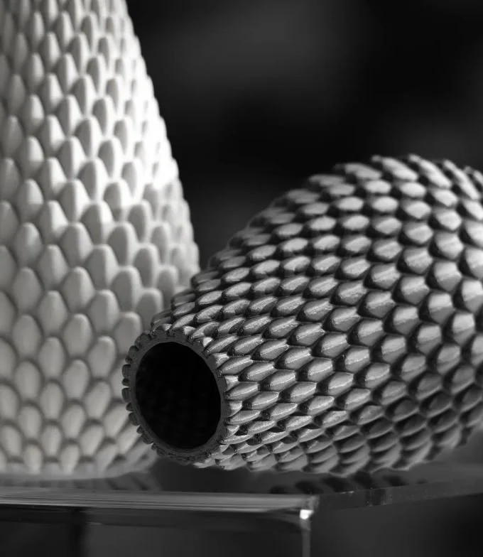 Close-up van twee litho- of gripschijven met ruw textuur, één zwart en één wit, op een reflecterend oppervlak.