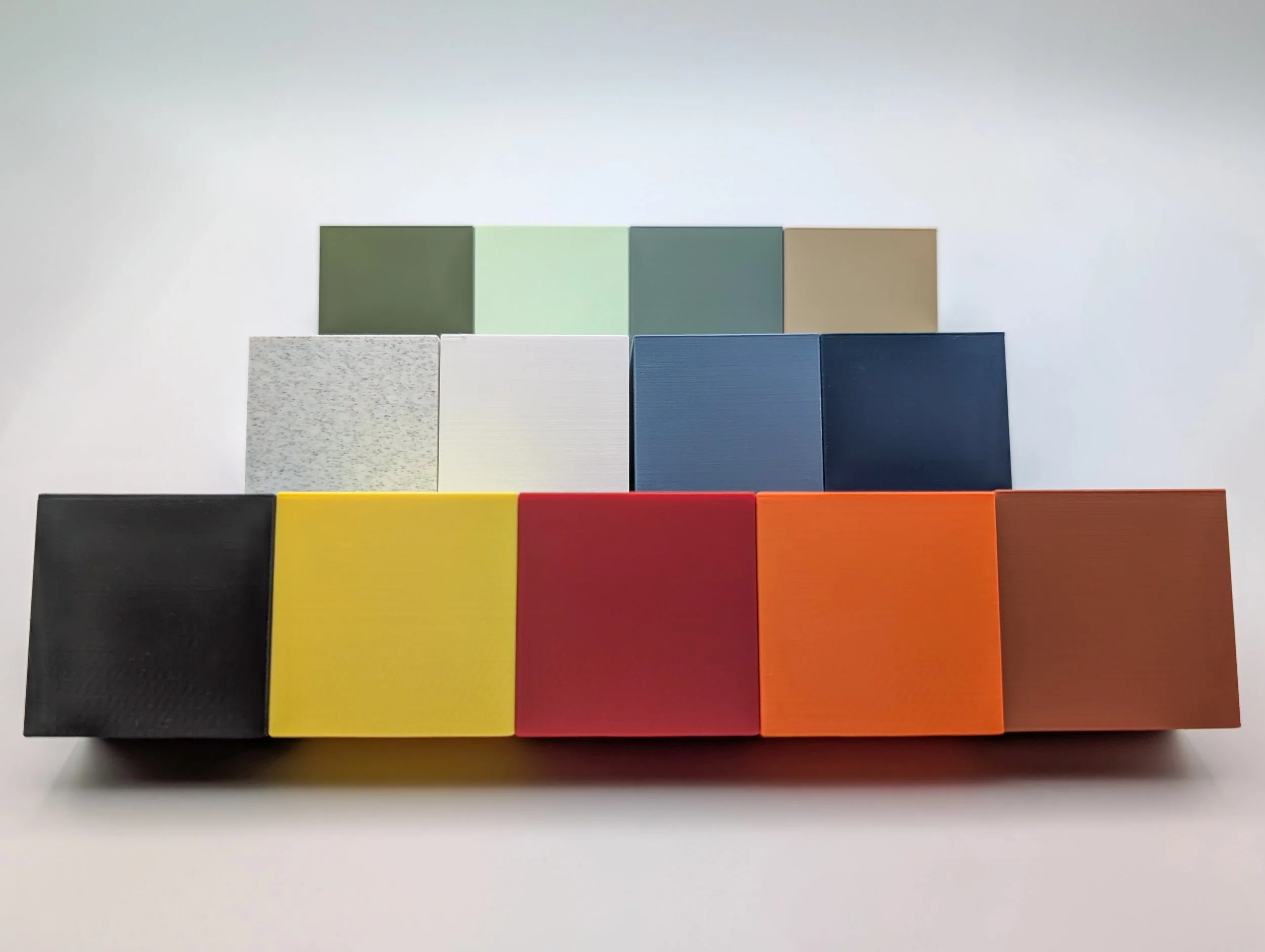 Tien 3D geprinte kubussen in verschillende kleuren, gerangschikt in drie rijen op een witte achtergrond.