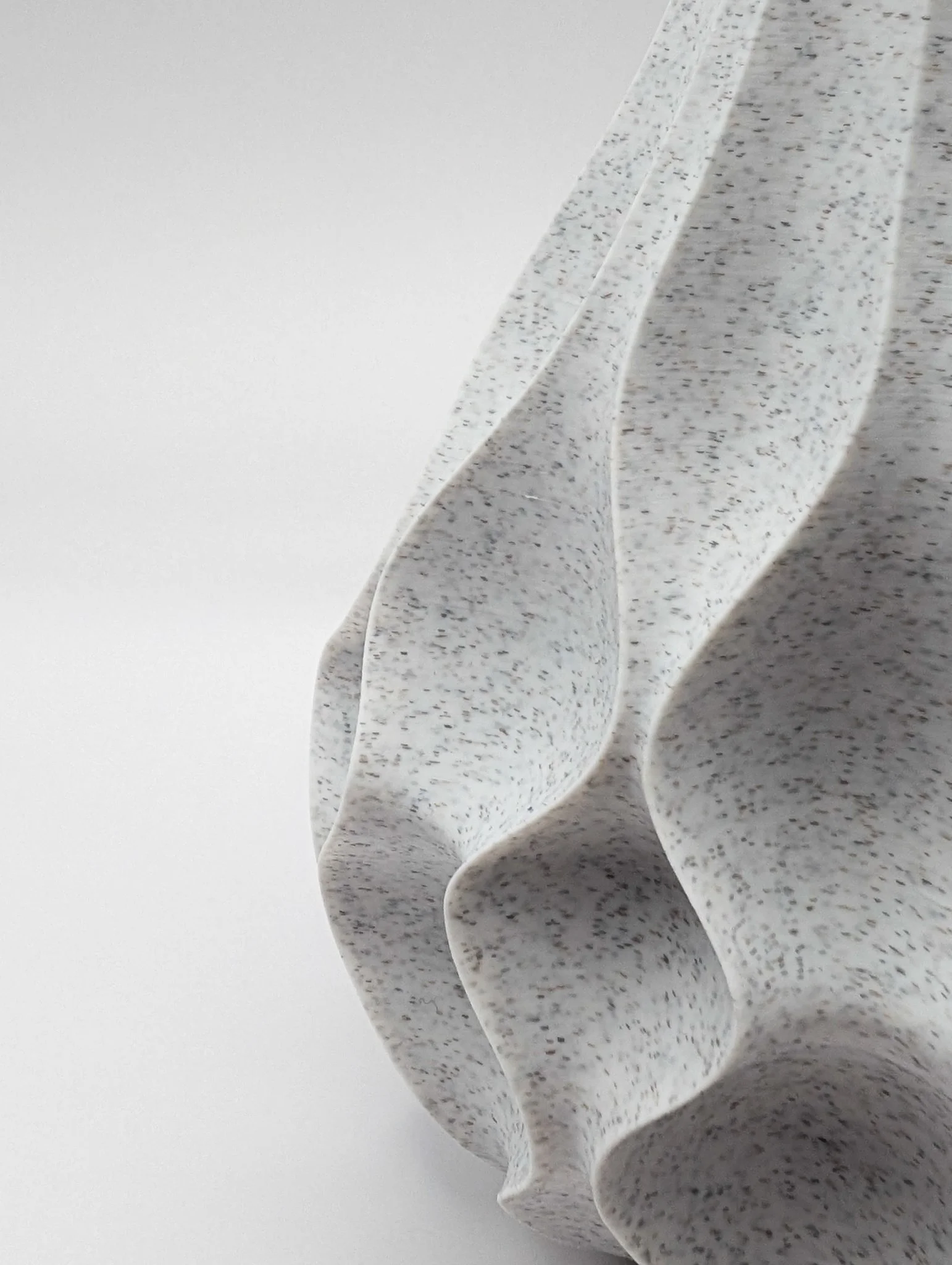 Close-up van een wit en grijs gekleurd object met een gegroepeerde, golvende structuur.