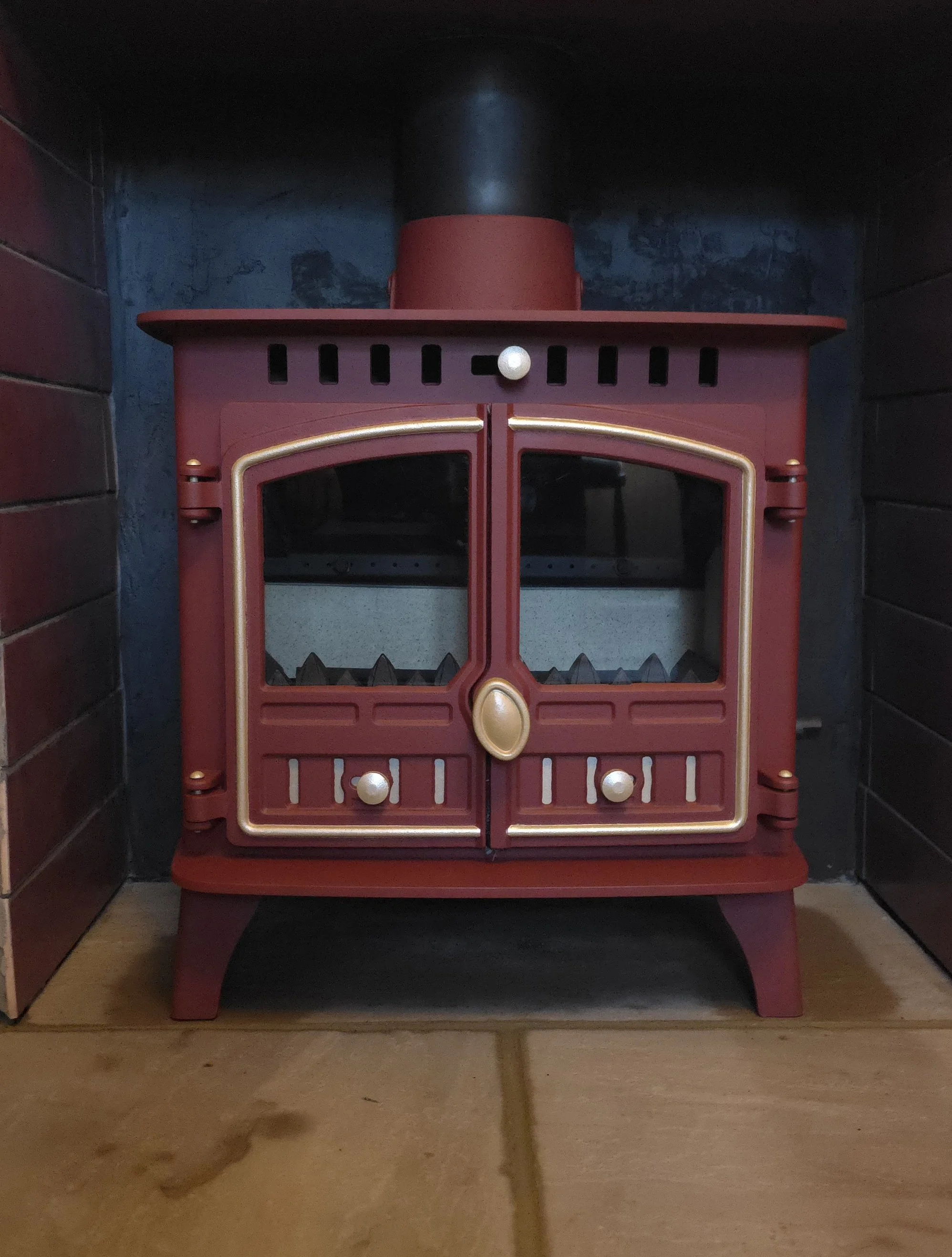 fully refurbished Herald Hunter 6kw Multifuel log burner, custom finished in Red & Gold and installed on a new sandstone hearth 