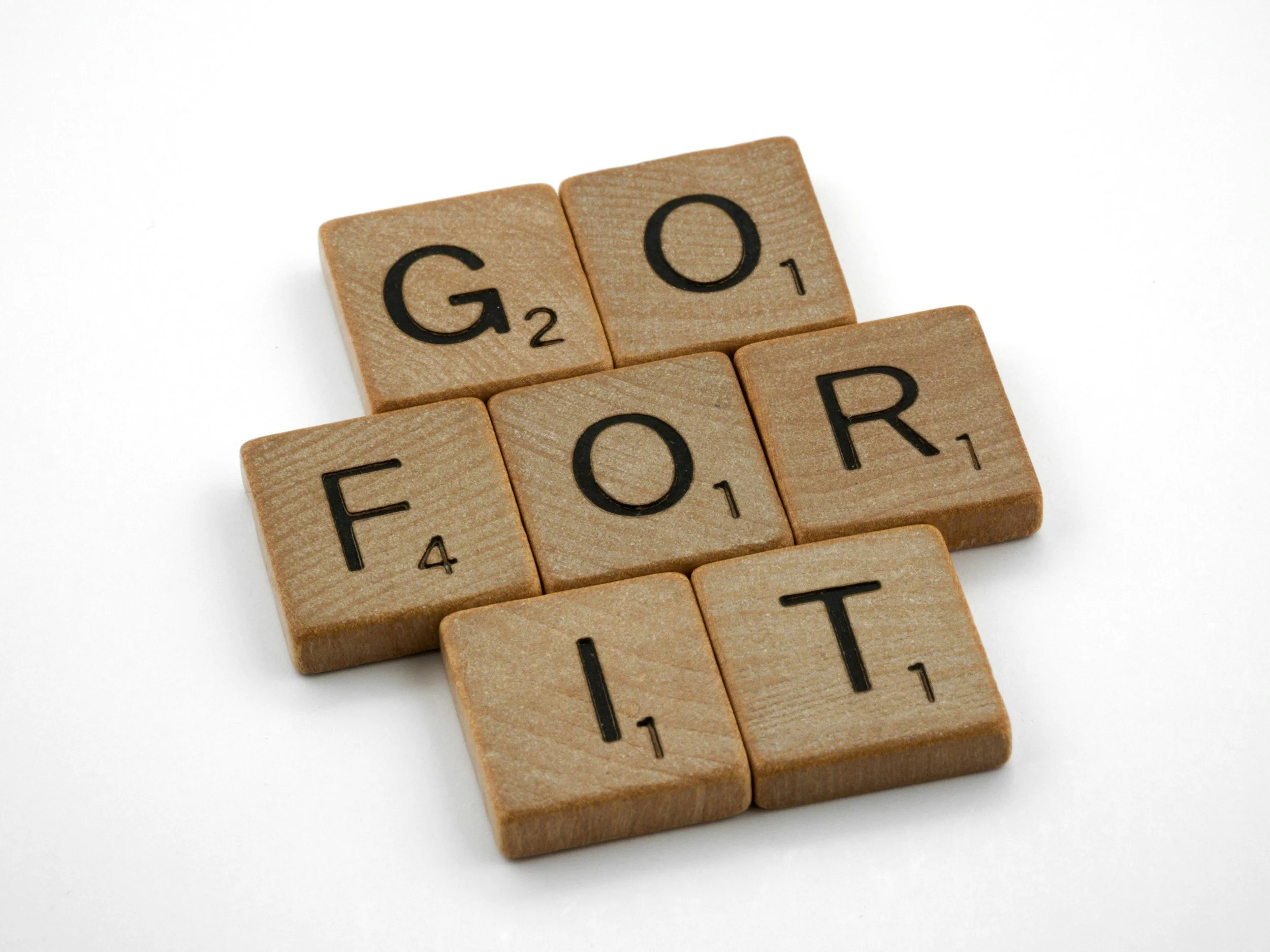Scrabble tiles spelling out the word 'FOOD' on a white background.