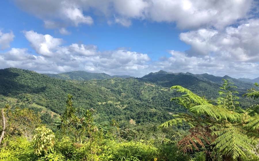 Lush green mountains under a partly cloudy sky.