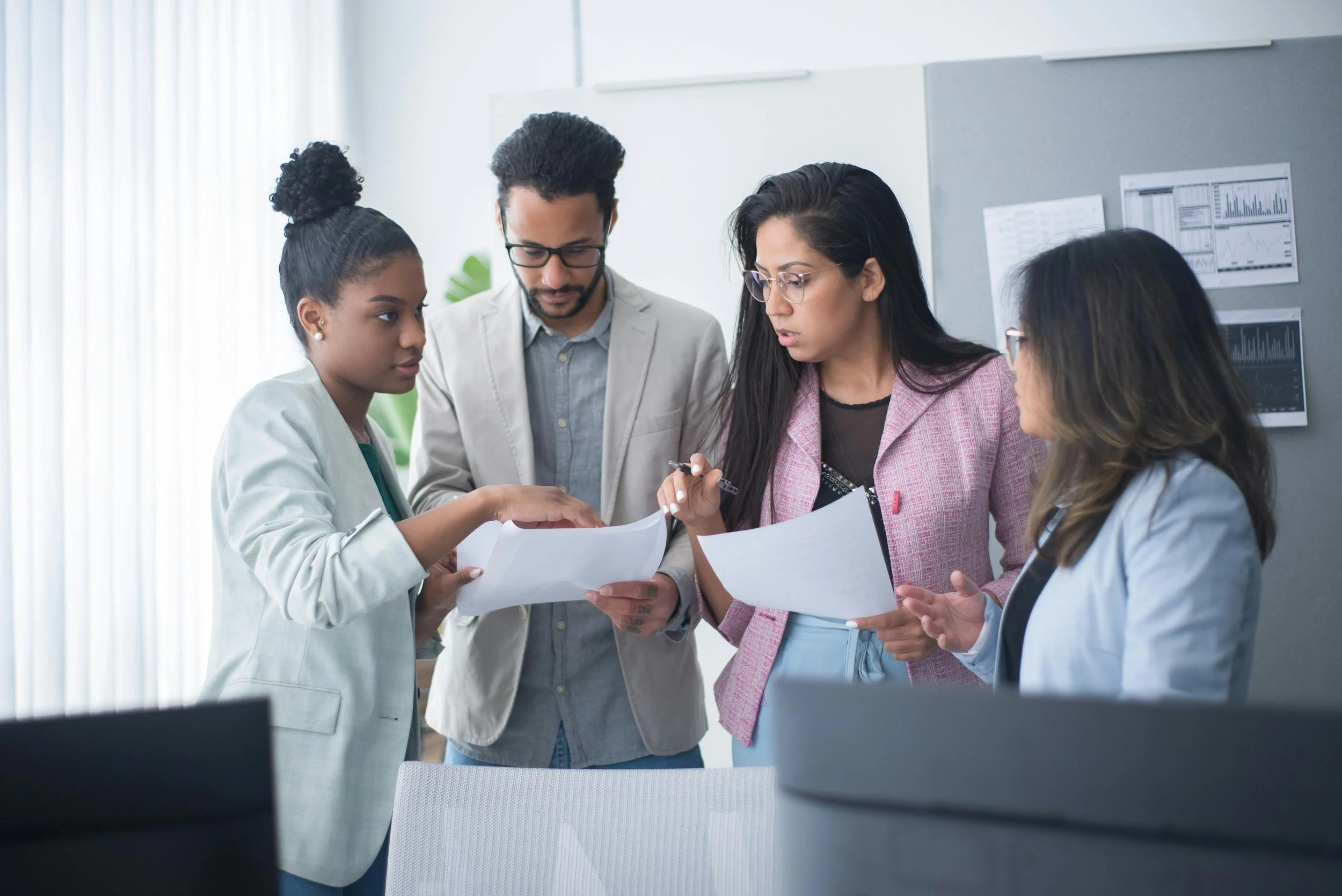 A diverse team of professional accountants and business advisors at High Point Accounting & Advisory collaborating on financial documents in a modern office.