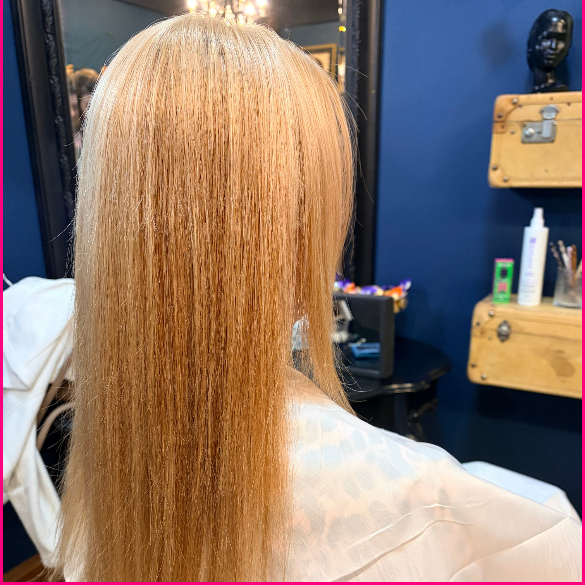 Back view of long, straight blonde hair in a salon chair