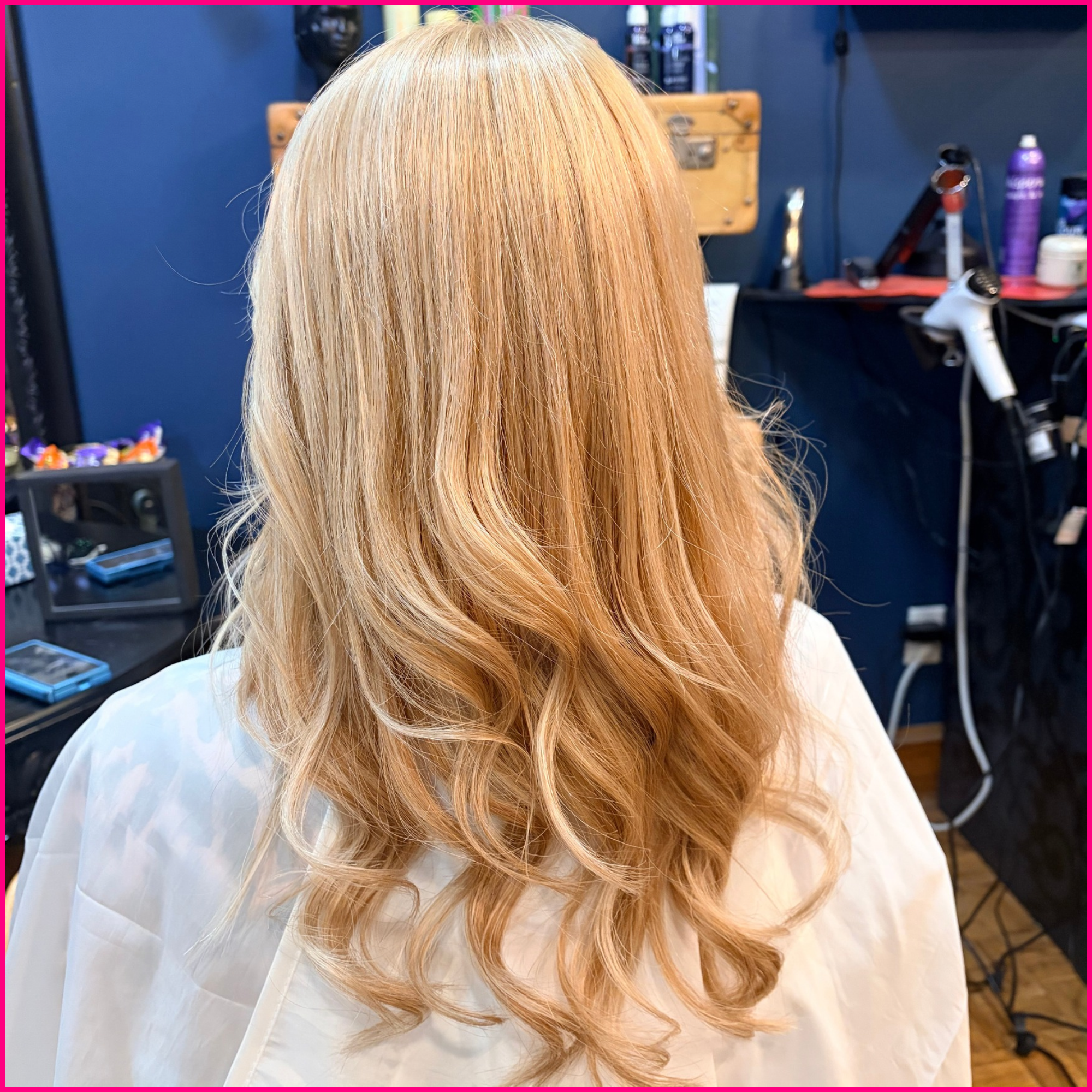 Back view of long, wavy blonde hair styled in a salon