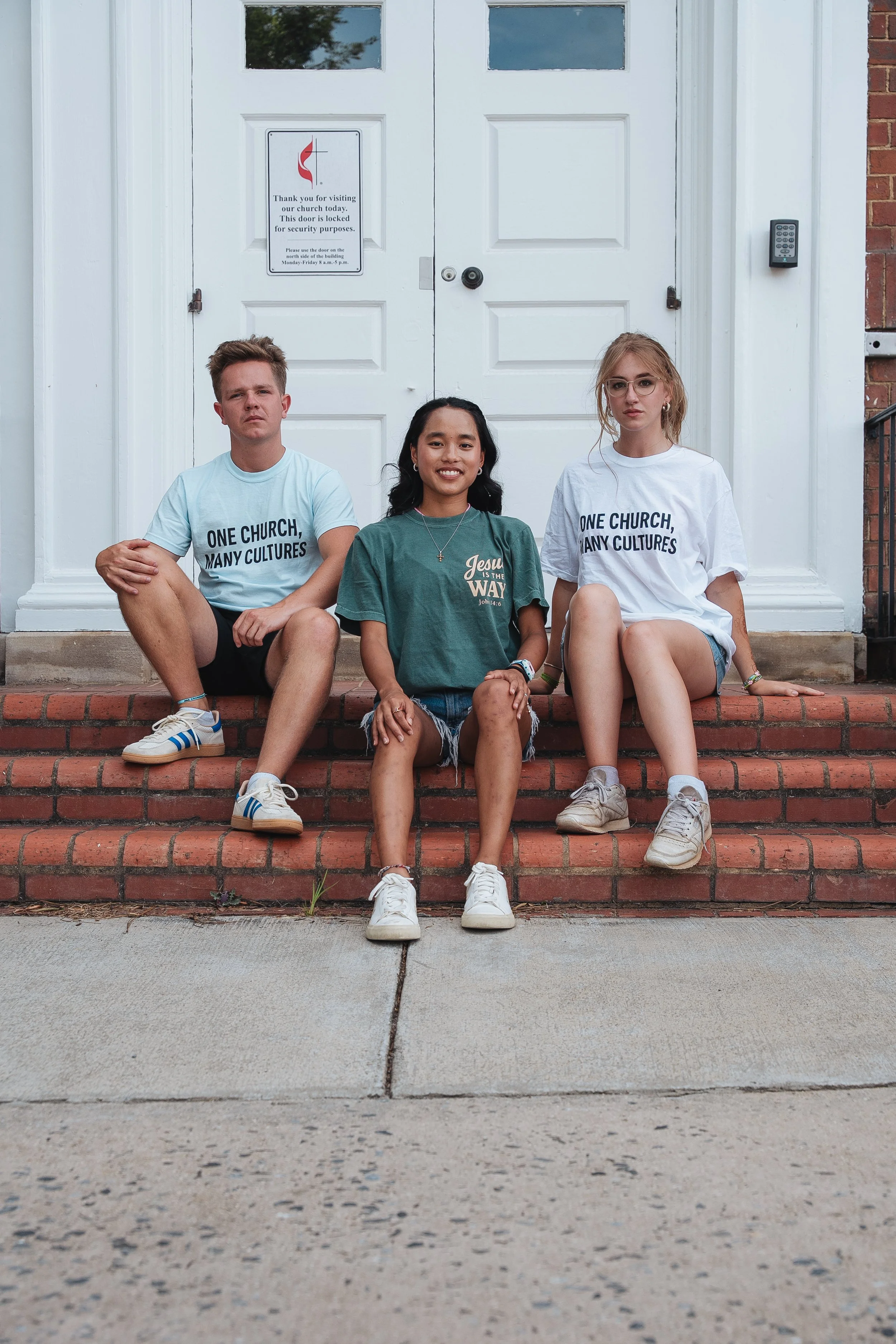 Friends wearing faith inspired Hope Awake shirts outside a church building
