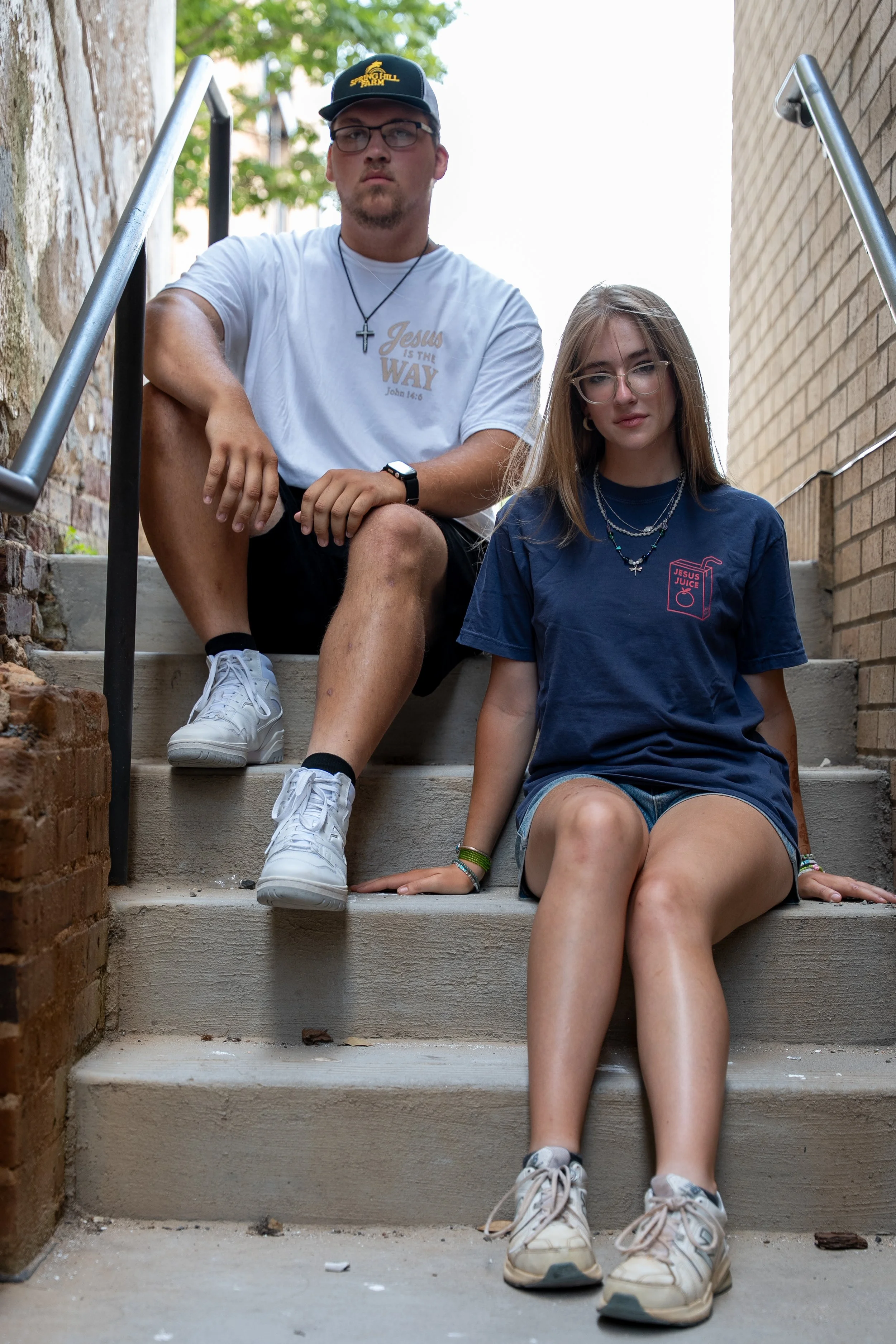 Models wearing Hope Awake Christian apparel sitting on brick steps