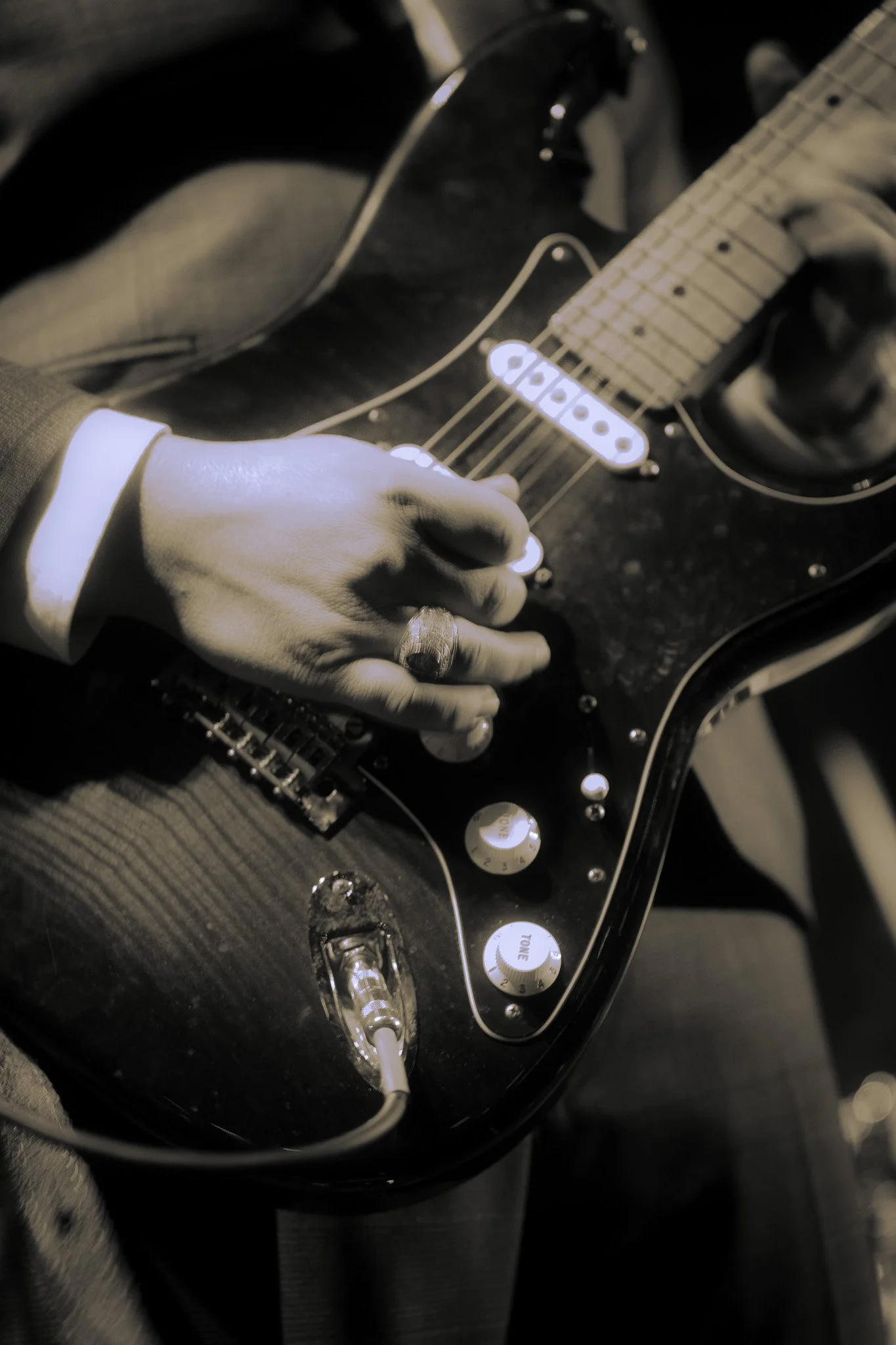 A person playing an electric guitar, up close detail shot with extra exposure