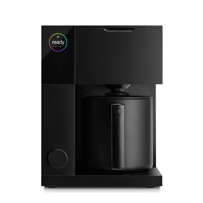 A black coffee machine with a digital display showing 'ready' with a rainbow circle around it, and a glass carafe underneath.