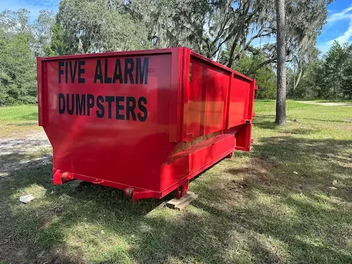 Large red 16-yard roll-off dumpster from Five Alarm Dumpsters ready for household junk removal or construction debris in Hernando, Pasco, and Citrus Counties.