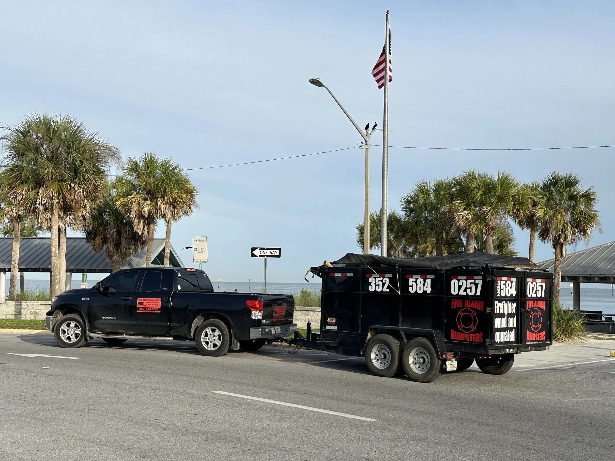 Five Alarm Dumpsters trailer providing dumpster rental service in Hudson, Florida near the waterfront