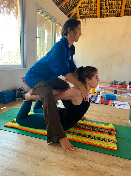 Sasha giving a yoga assist to a student at Yandara Institute in Baja California Sur Mexico.