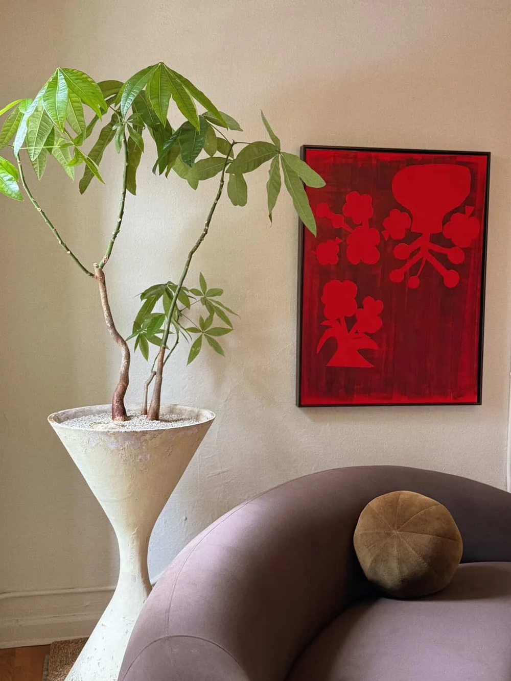 A money tree in a Willy Guhl hourglass planter beside a red painting