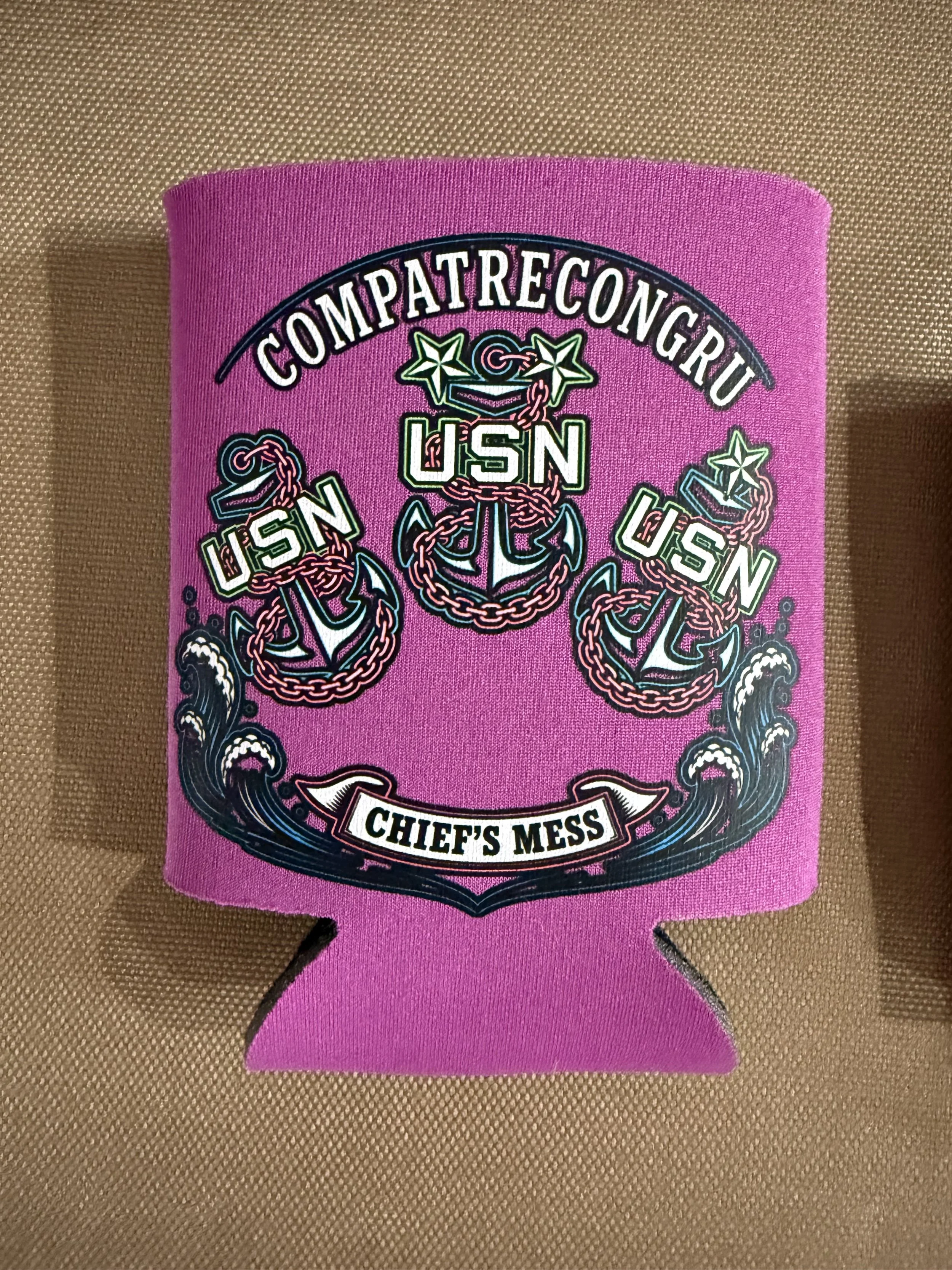 Close-up of a pink embroidered patch with the words "COMPATRECONGRU" and "CHIEF'S MESS" and military-themed graphics, including anchors and chains.