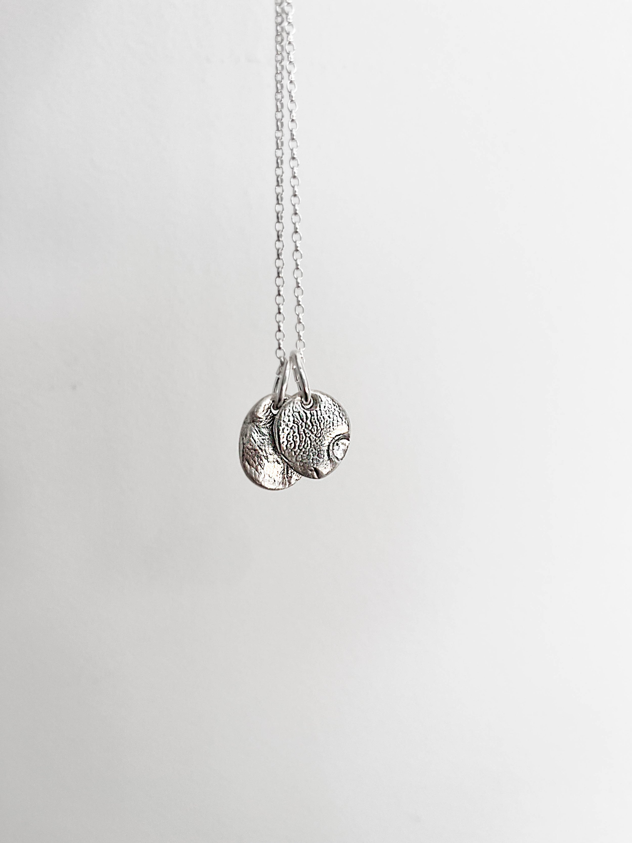 Close-up of personalised dog nose print pendant on a clean white background. Custom silver necklace made from your dog’s real nose impression – meaningful and unique pet remembrance jewellery.