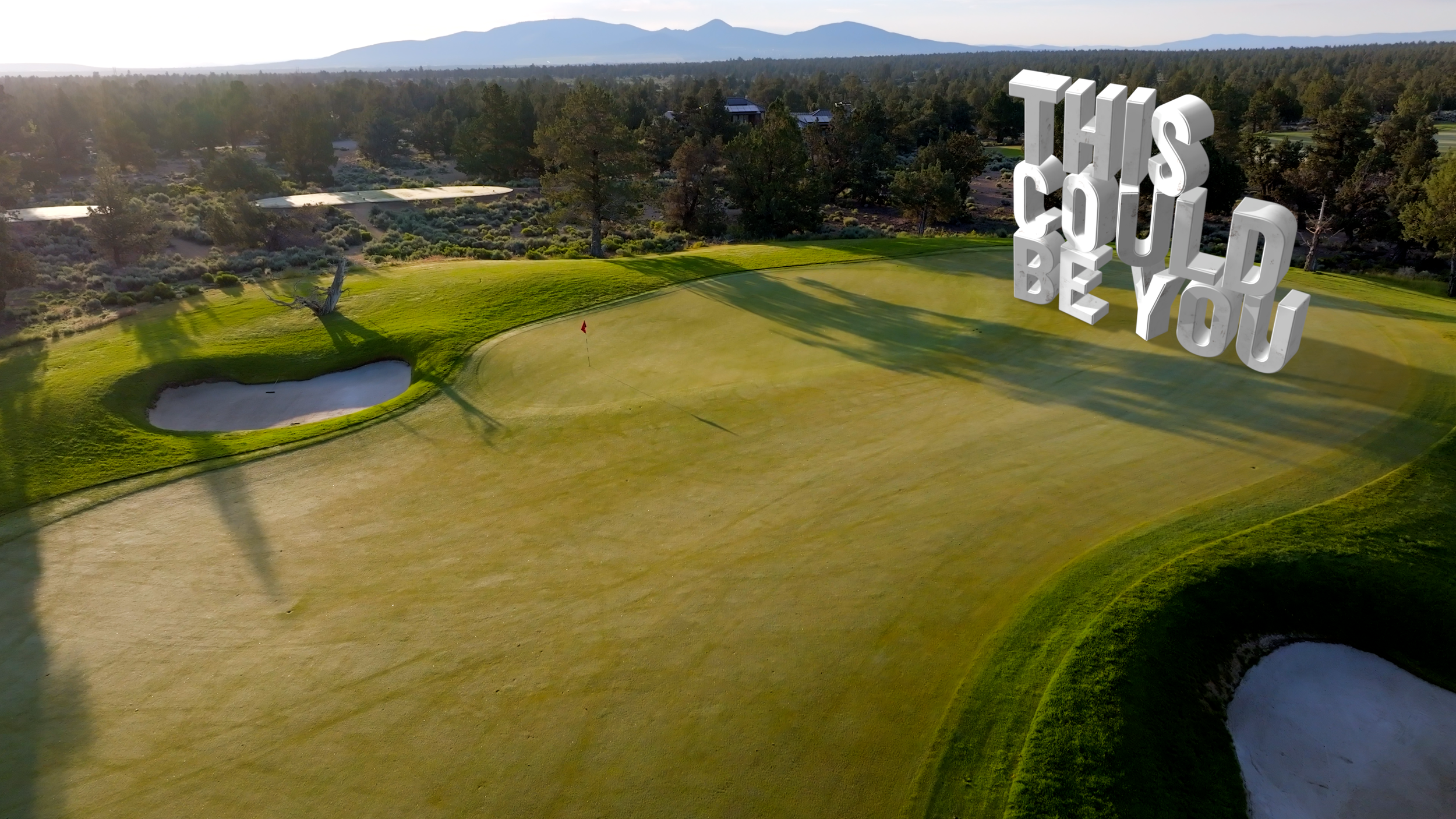 A golf course with sand bunkers, green grass, a flag, trees, and mountains in the background. 3D text reads 'THIS COULD BE YOU' in the sky.
