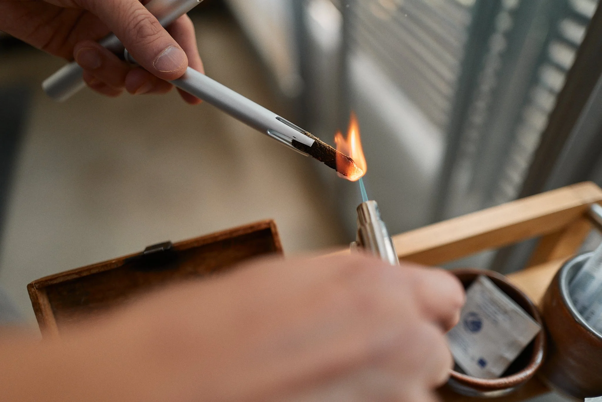 Person holding a moxa tube releasing smoke