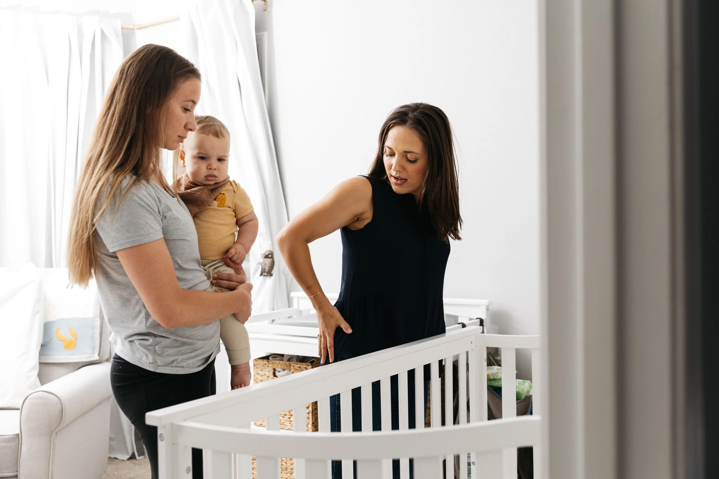 pelvic floor therapist sarah kate orton with Charleston Pelvic Health helps postpartum mom recover and safely lift baby in and out of crib without pain in back, hips, wrist, and hands