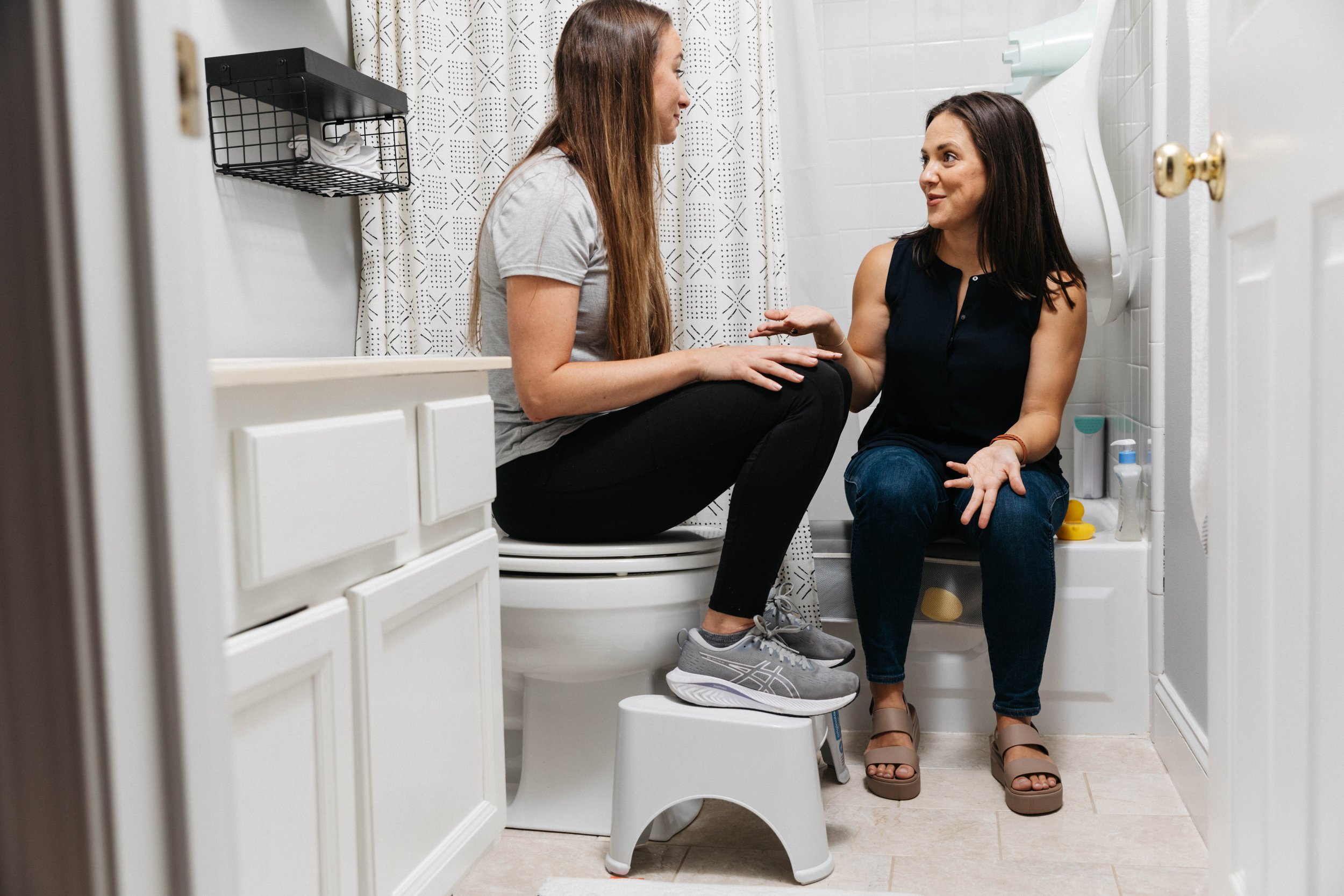 sarah kate orton pelvic floor therapist charleston, sc helps postpartum client in-home in bathroom with incontinence, constipation through better positioning and body mechanics