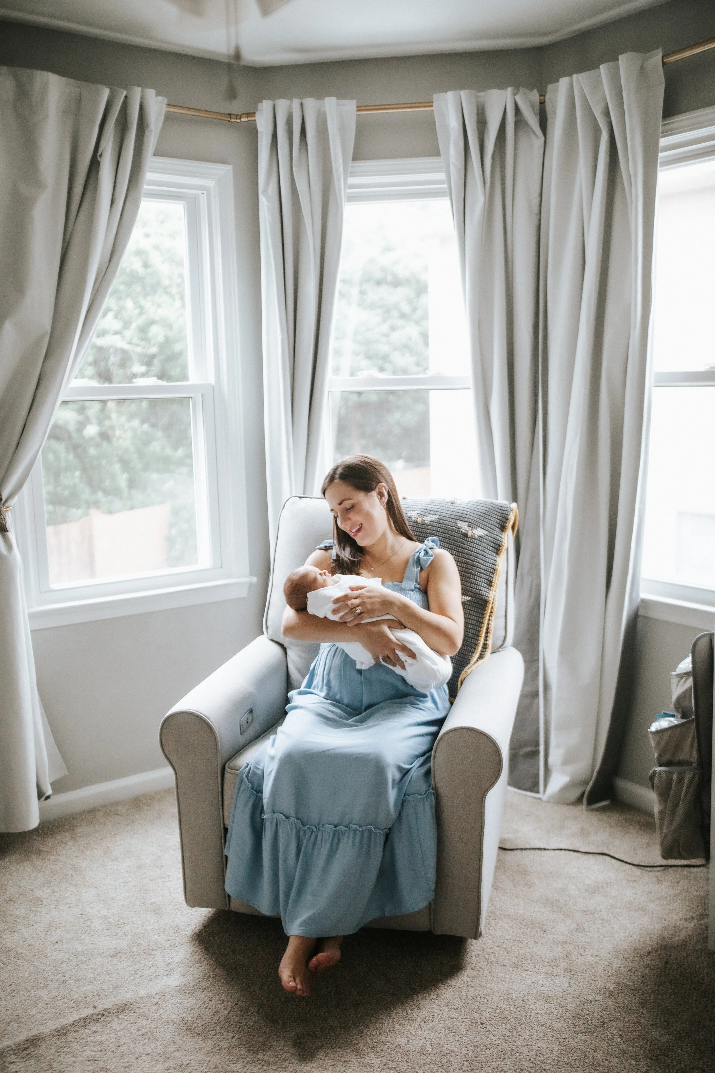 pelvic floor therapist holds newborn baby during postpartum recovery