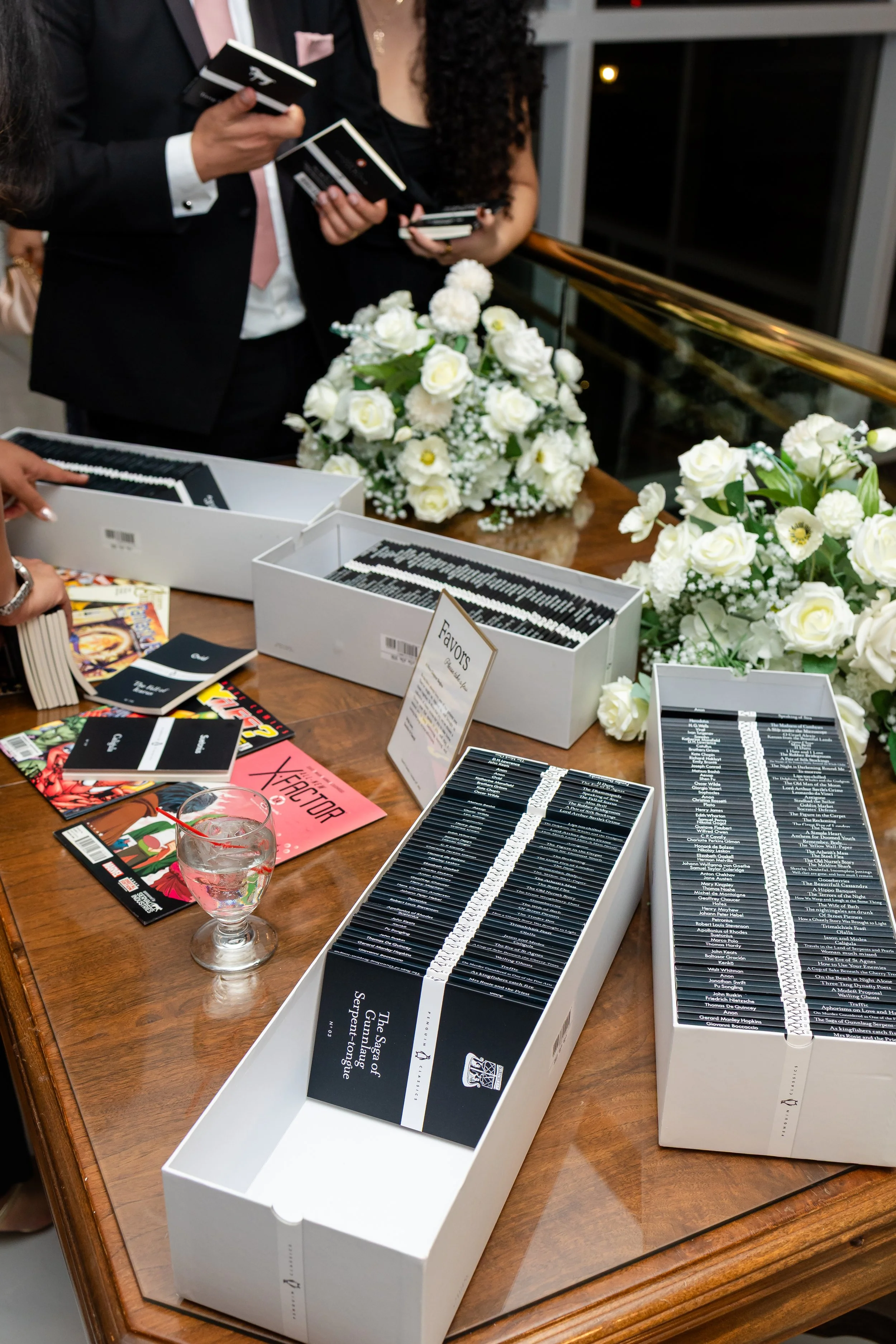 Guests are looking at the boxes of classic novels and comic books given as wedding favors. 
