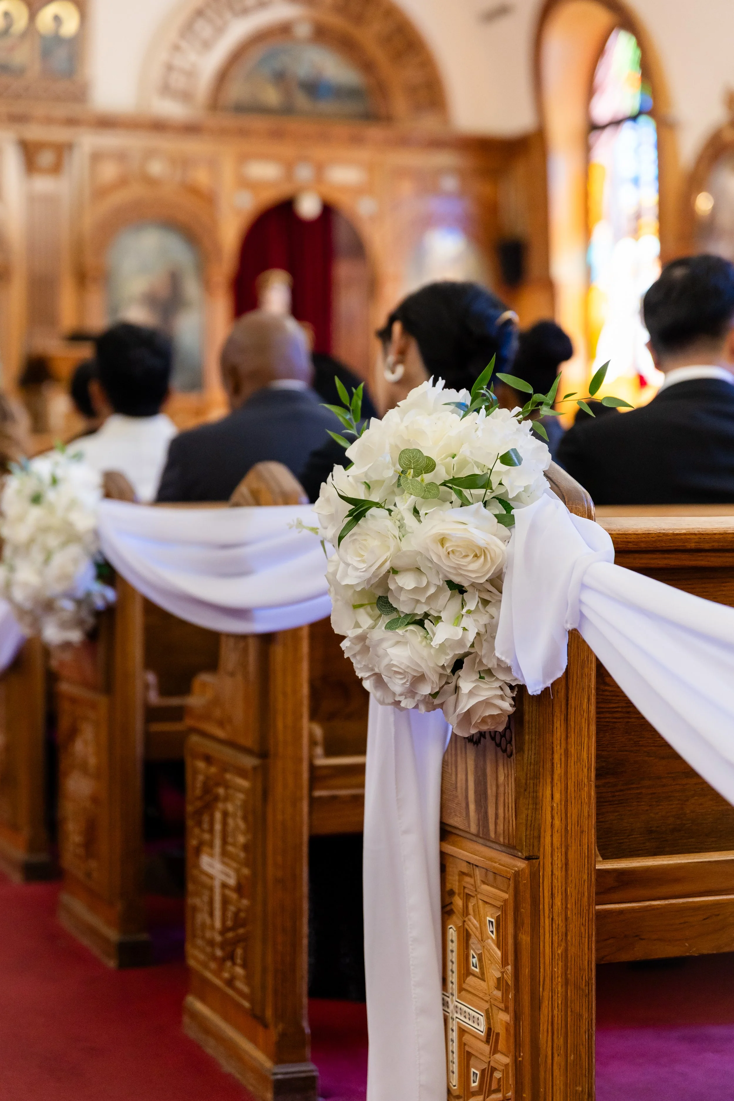 Flower arrangement and drapery hanging from the pew at St. Mary's Coptic Orthodox church in New Jersey.