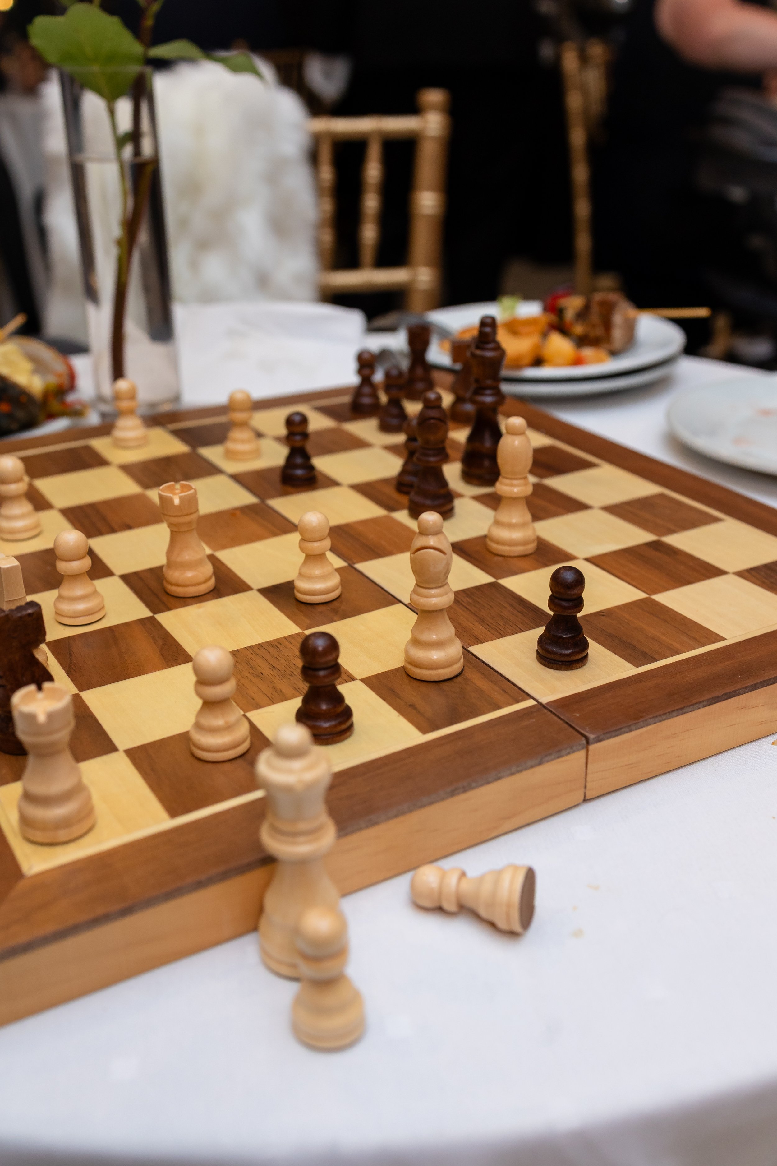 A chess board game is laid out on the table during cocktail hour. 