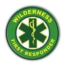 Wilderness First Responder badge with green background and medical symbol