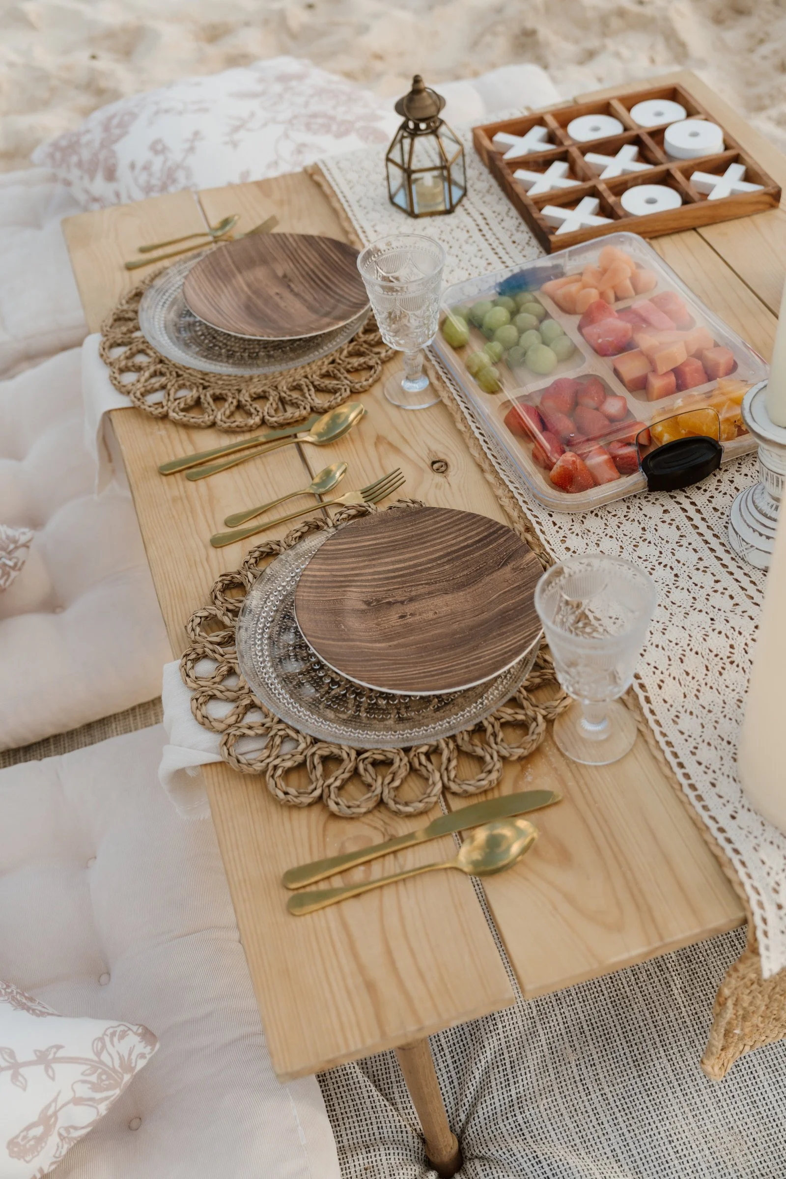 Candlelight, glassware and handcrafted table details at a luxury outdoor picnic.
