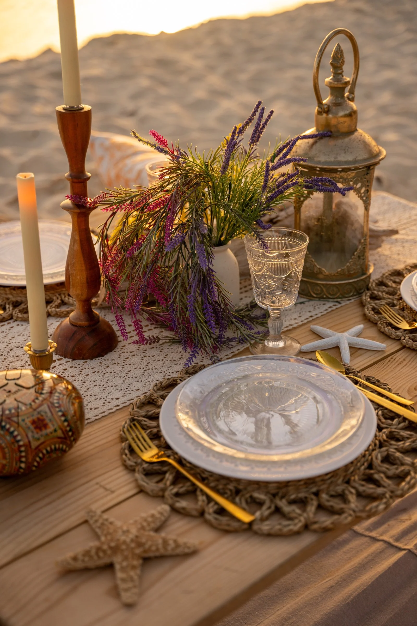 Layered glassware, flowers and tableware arranged for an elegant Cayman beach picnic.