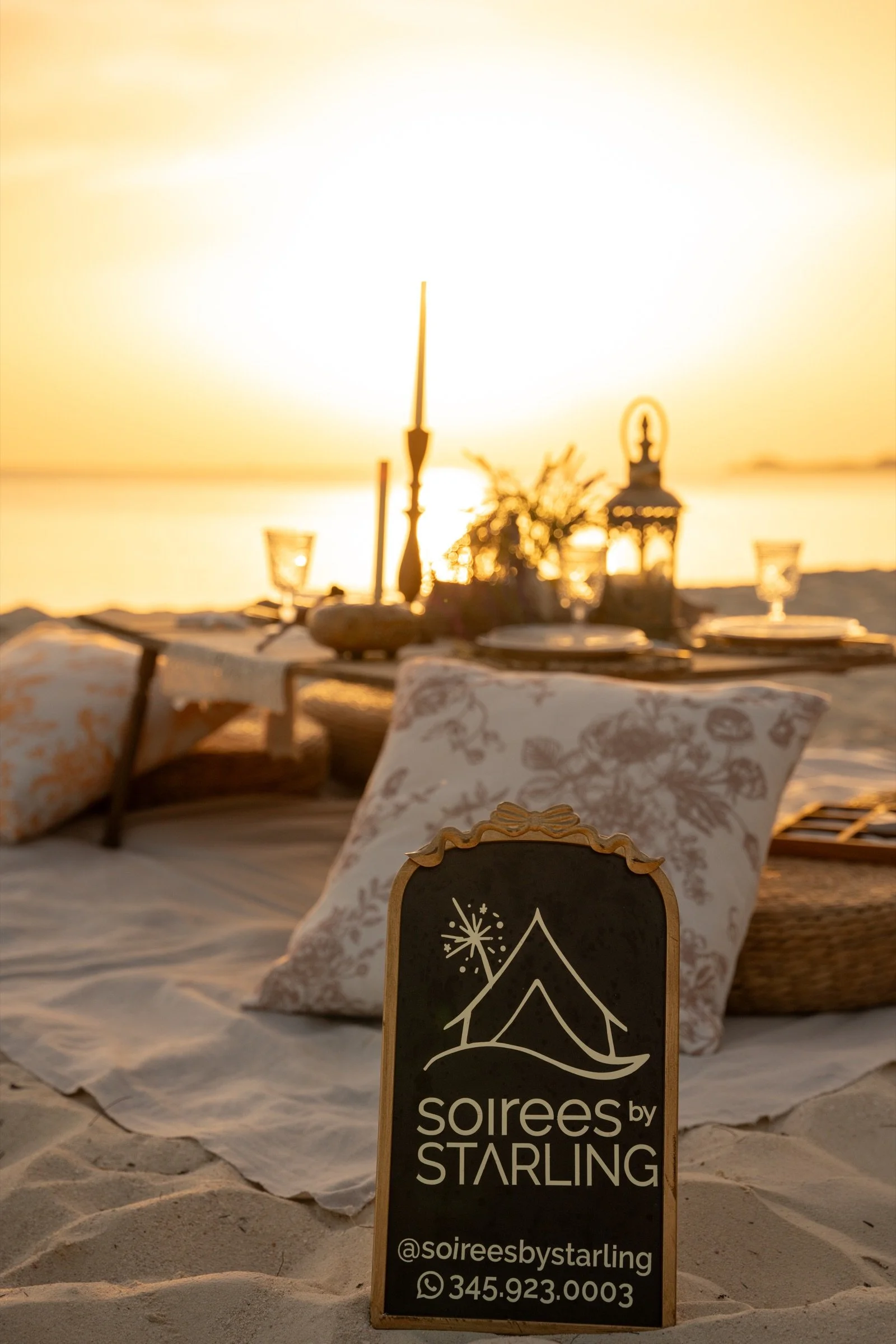 A couple enjoying a relaxed, beautifully styled beach picnic beside the Caribbean Sea.